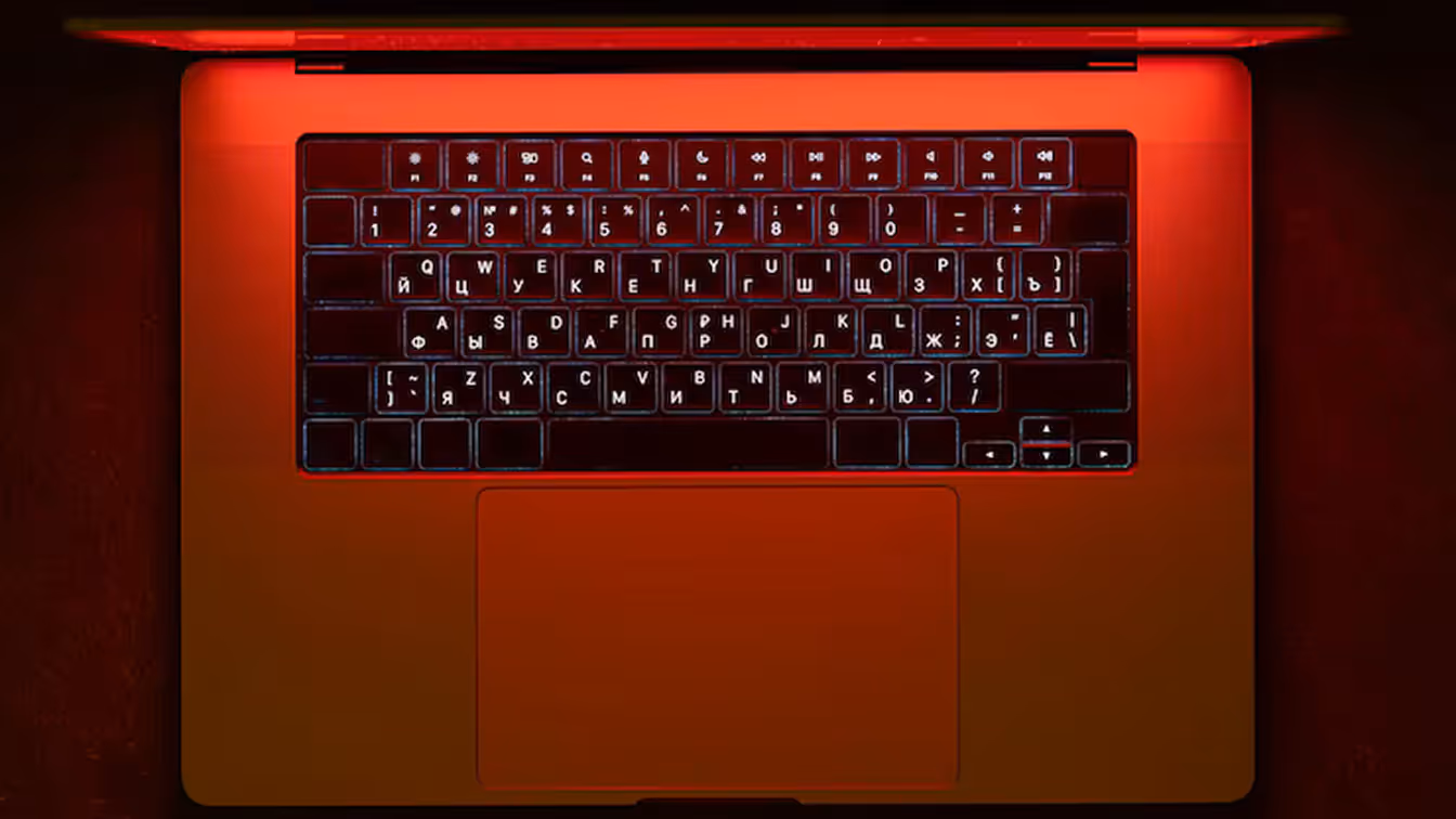 Laptop keyboard illuminated by red light, symbolizing cybersecurity threats targeting law firms.