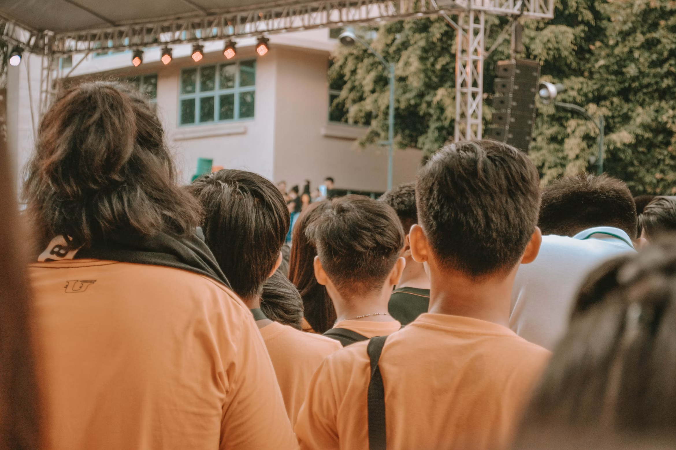Crowd of students seen from behind at a campus event, representing synthetic identities hidden in college enrollment fraud