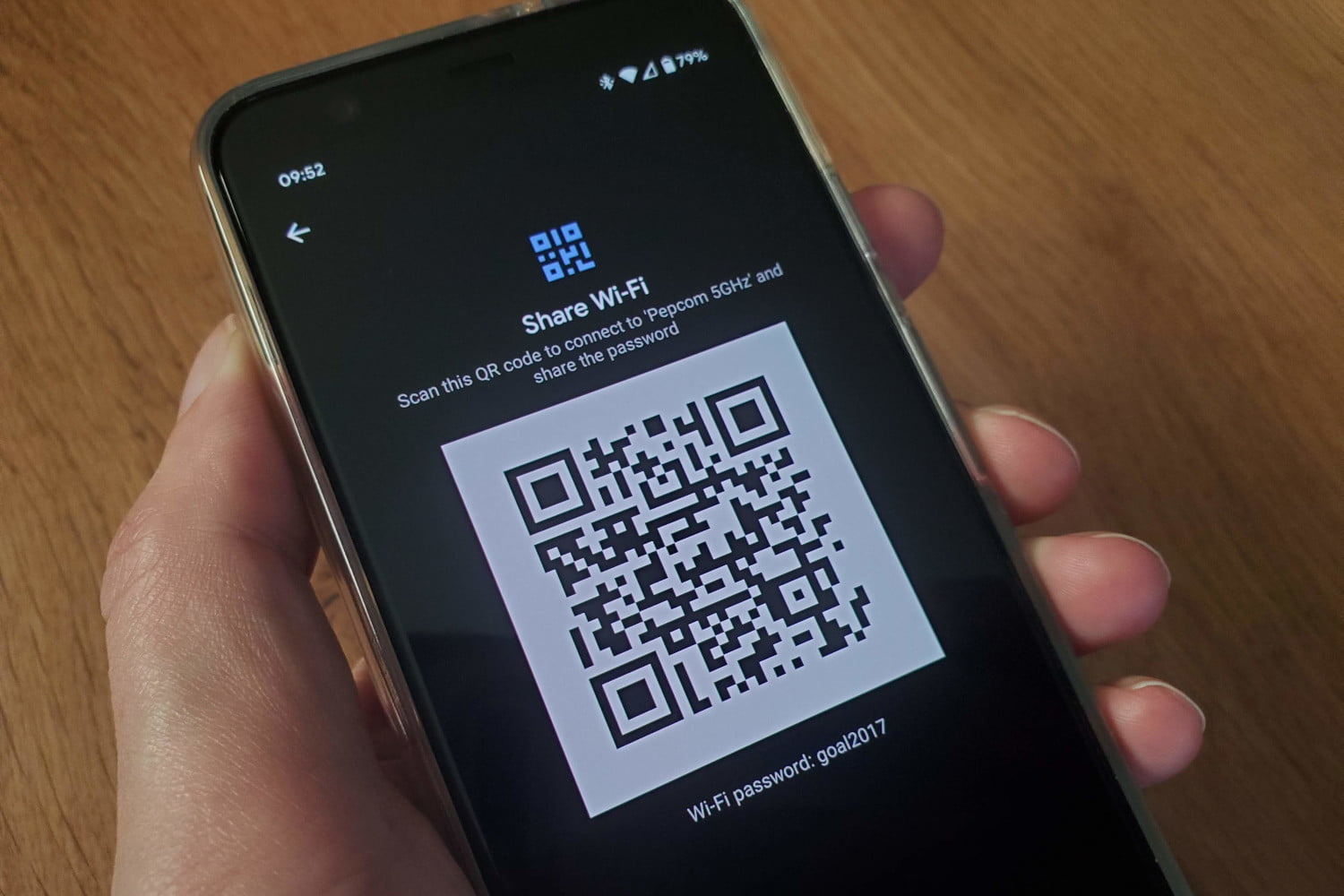 Hand holding a smartphone displaying a QR code on screen, illustrating how quishing uses QR codes to phish users