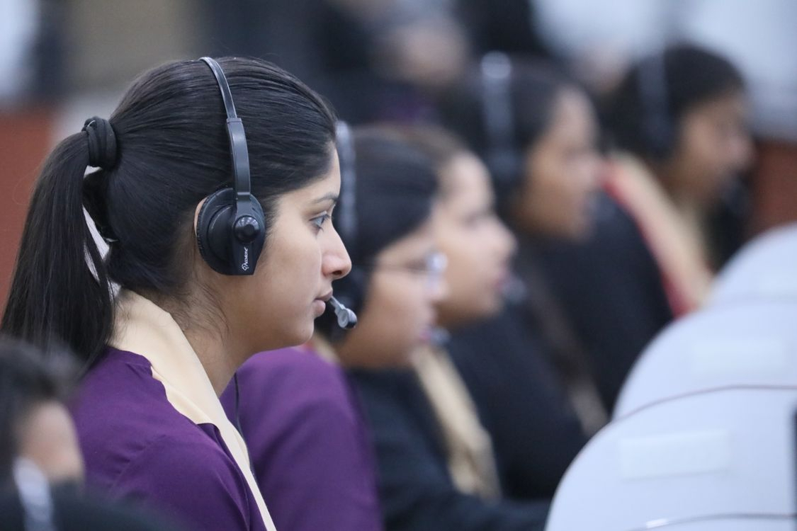 Row of headset-wearing call center agents at work, illustrating the trusted access attackers exploit in BPO environments