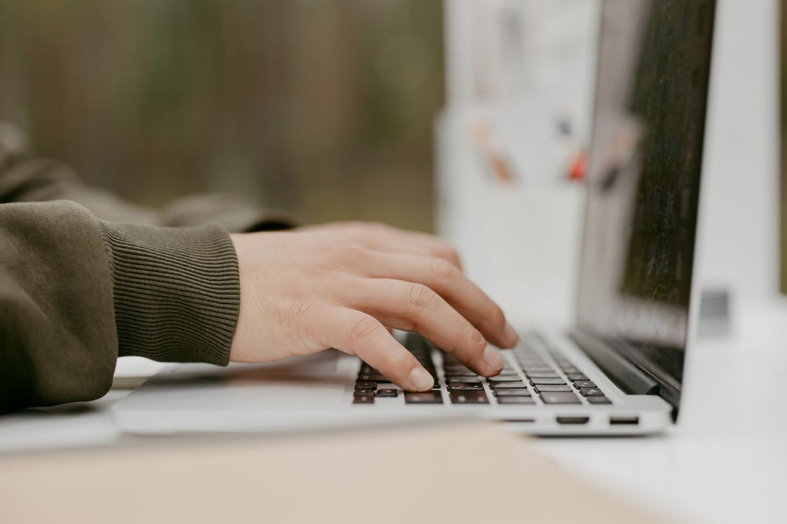 Hands typing on a laptop keyboard, evoking the credential access and trusted logins attackers abuse in BPO environments
