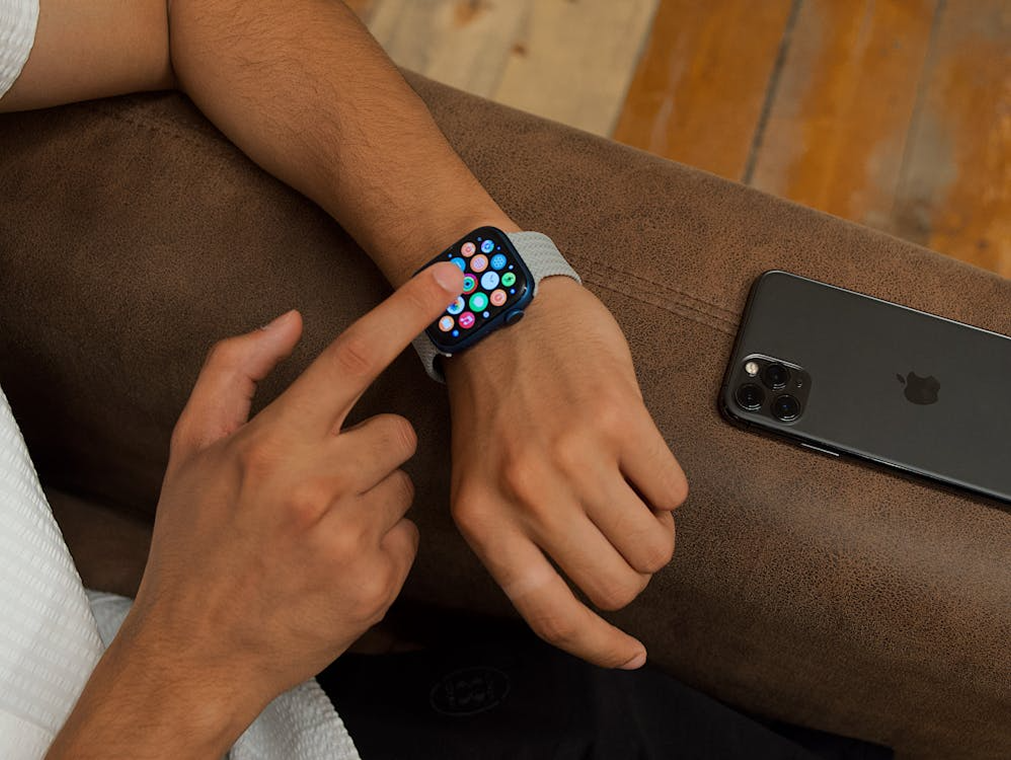 Person using smartwatch and smartphone, illustrating how SMS and mobile-based social engineering attacks bypass traditional email security.