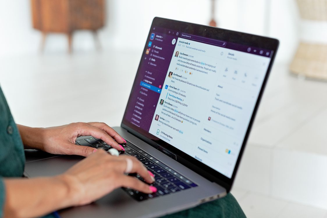 Employee using a collaboration platform on laptop, illustrating how attackers exploit Slack and Microsoft Teams.