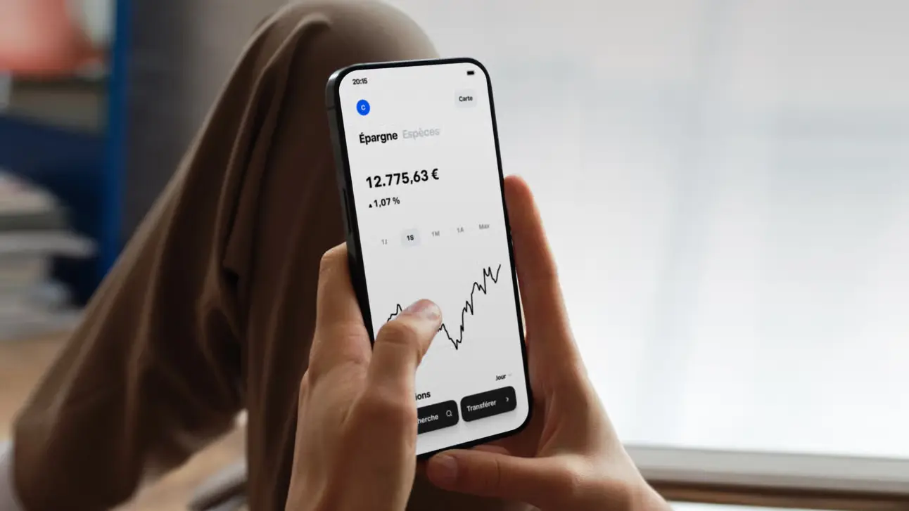 Personne consultant l’application Trade Republic sur smartphone avec graphique boursier et solde affiché