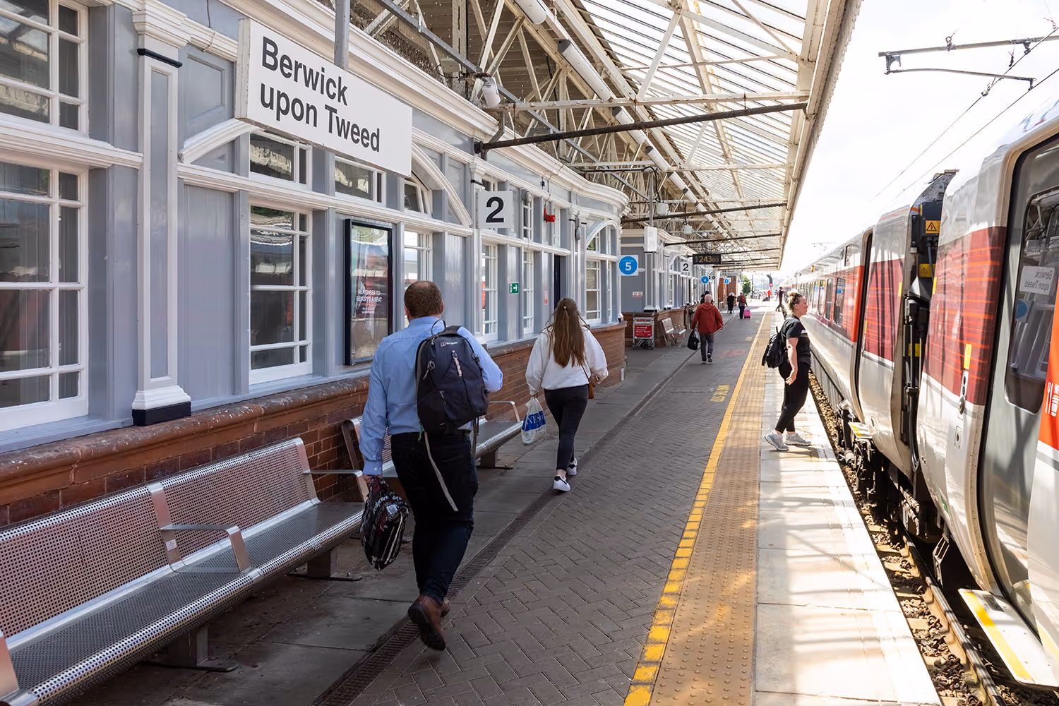 Berwick upon Tweed train station platform, with people boarding a train