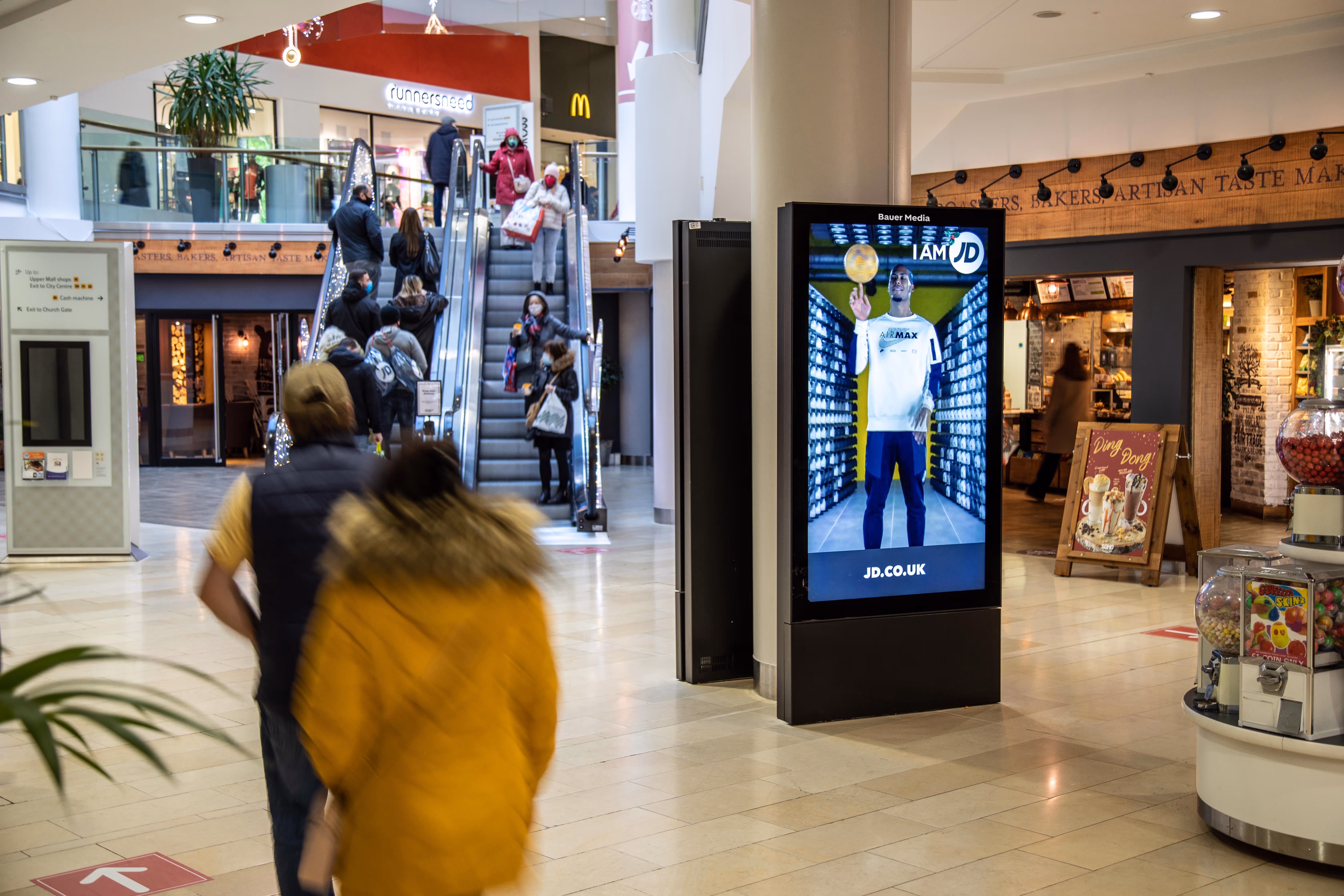 Digital shopping centre advertising screen displaying a JD ad campaign