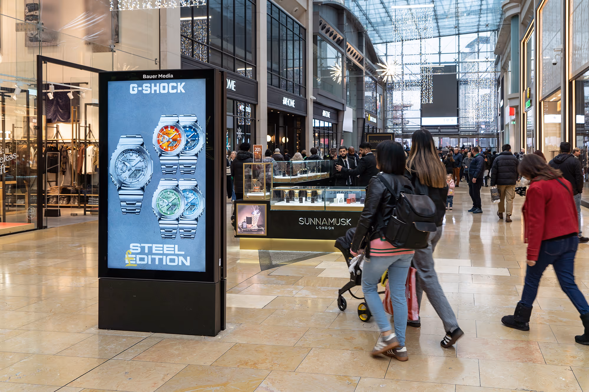 Digital shopping centre advertising screen displaying a Casio ad campaign