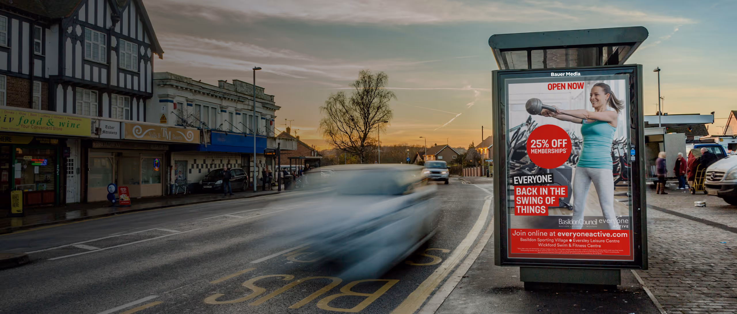 Gym "Open now" ad on the roadside as cars drive past
