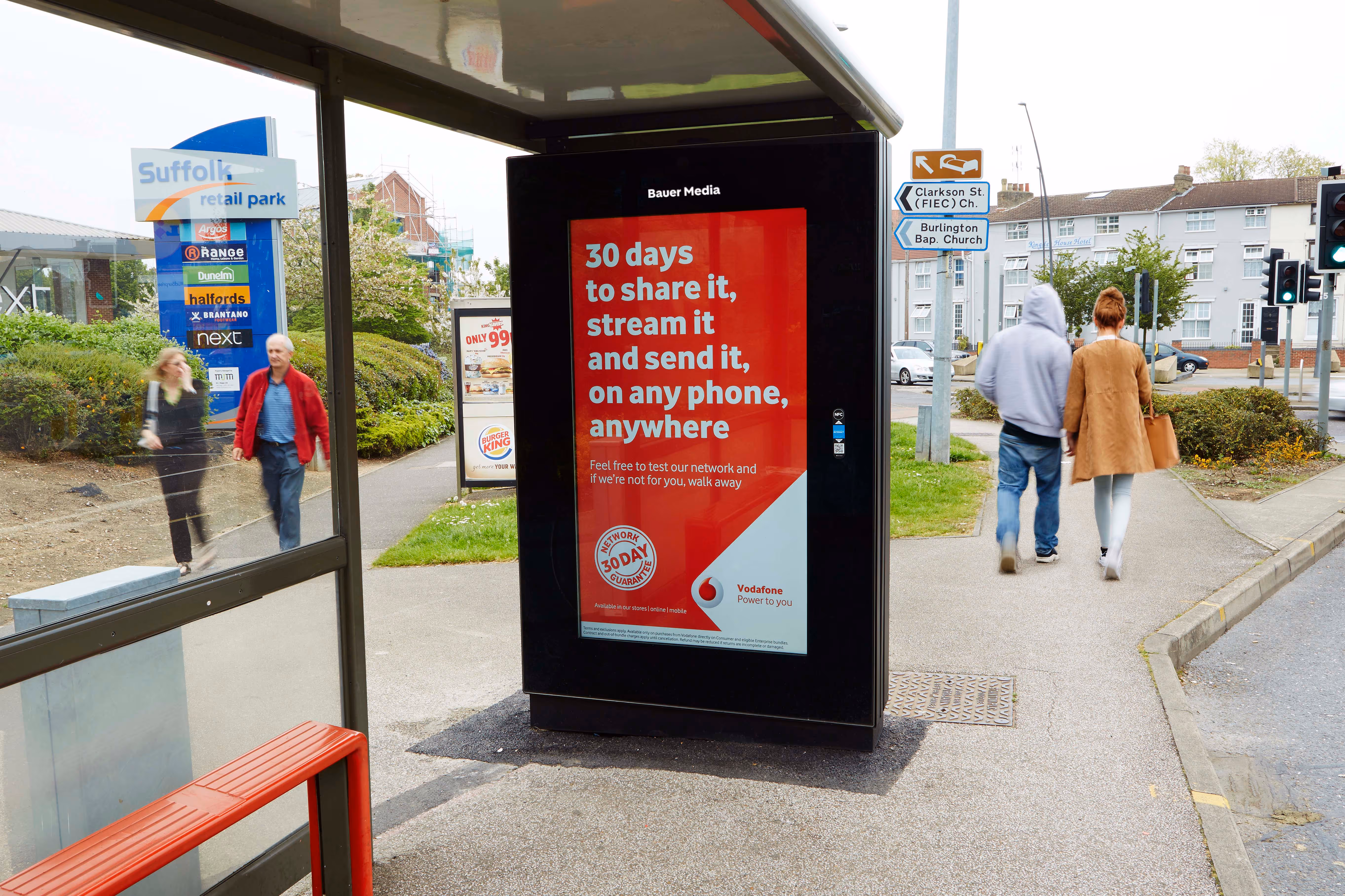 Vodafone's ad at a Bus Shelter as couples walk past