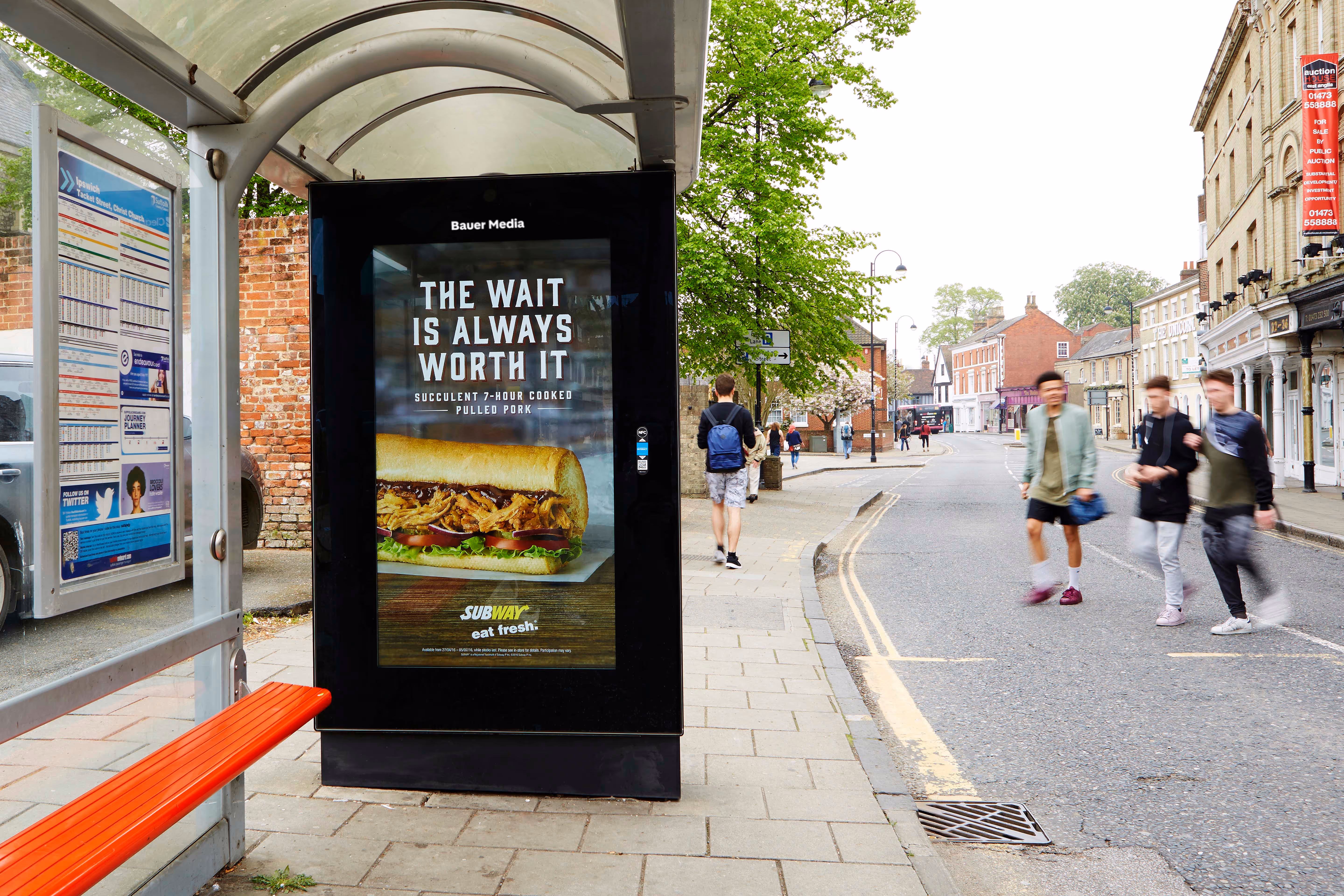 Subways "The wait is always worth it" on a Bus Shelter with people walking past
