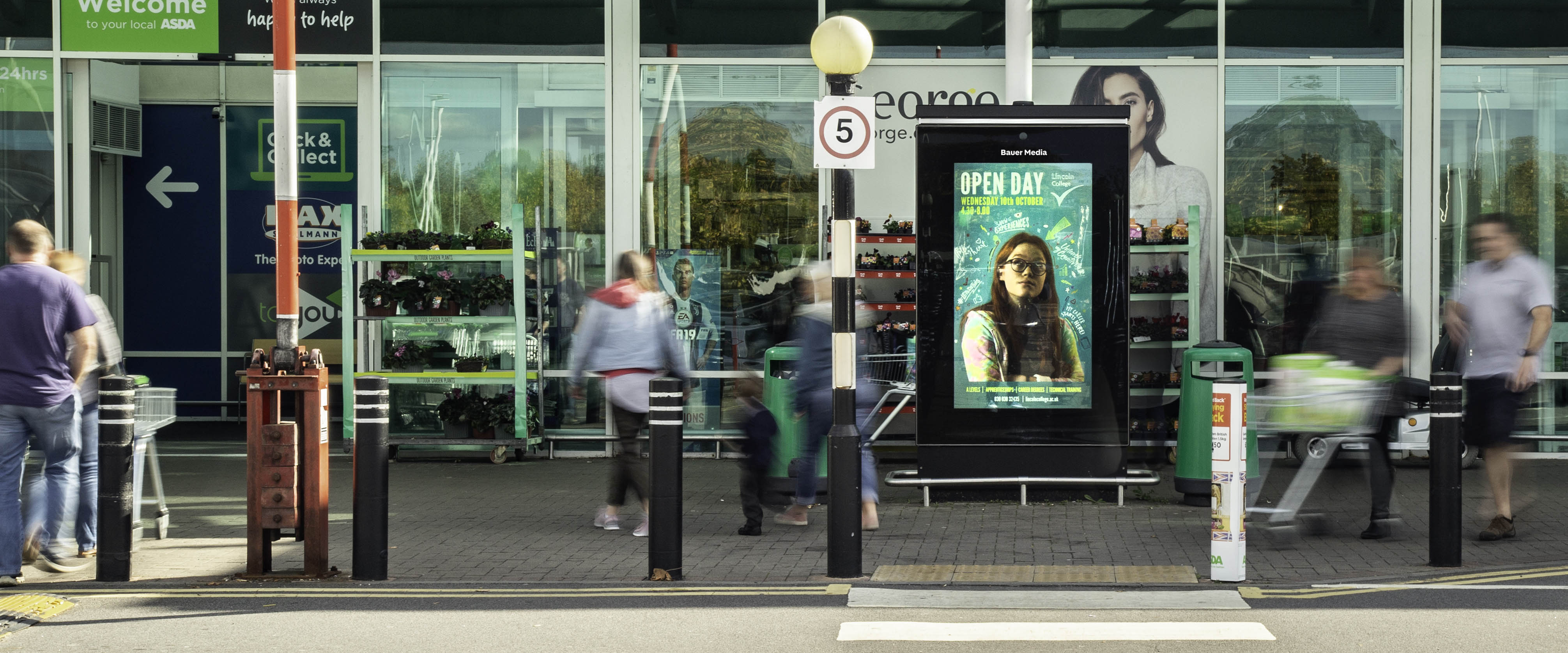 Lincoln College advertising on a digital Asda Live screen at the entrance