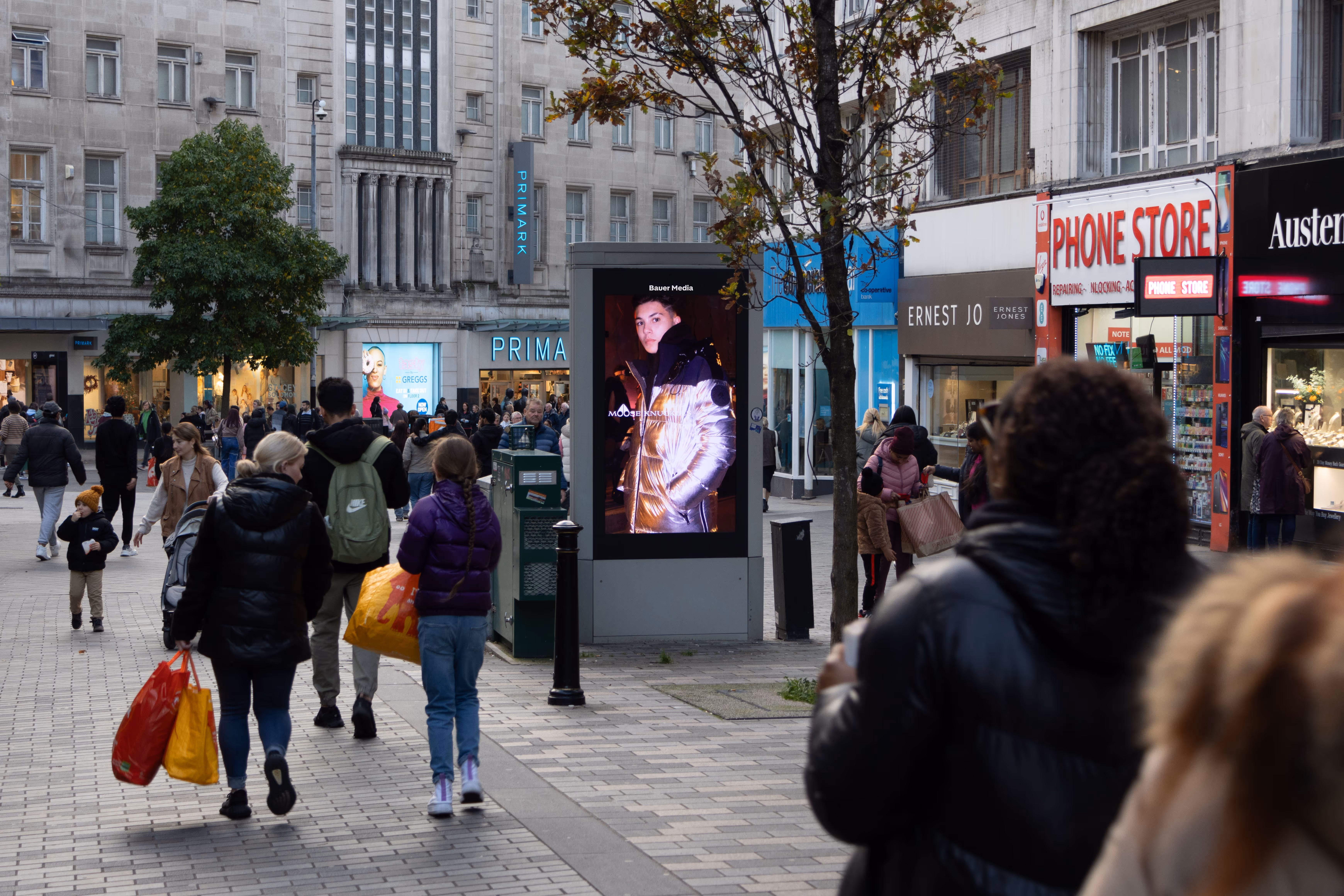 Digital advertisement in the middle of a busy high street