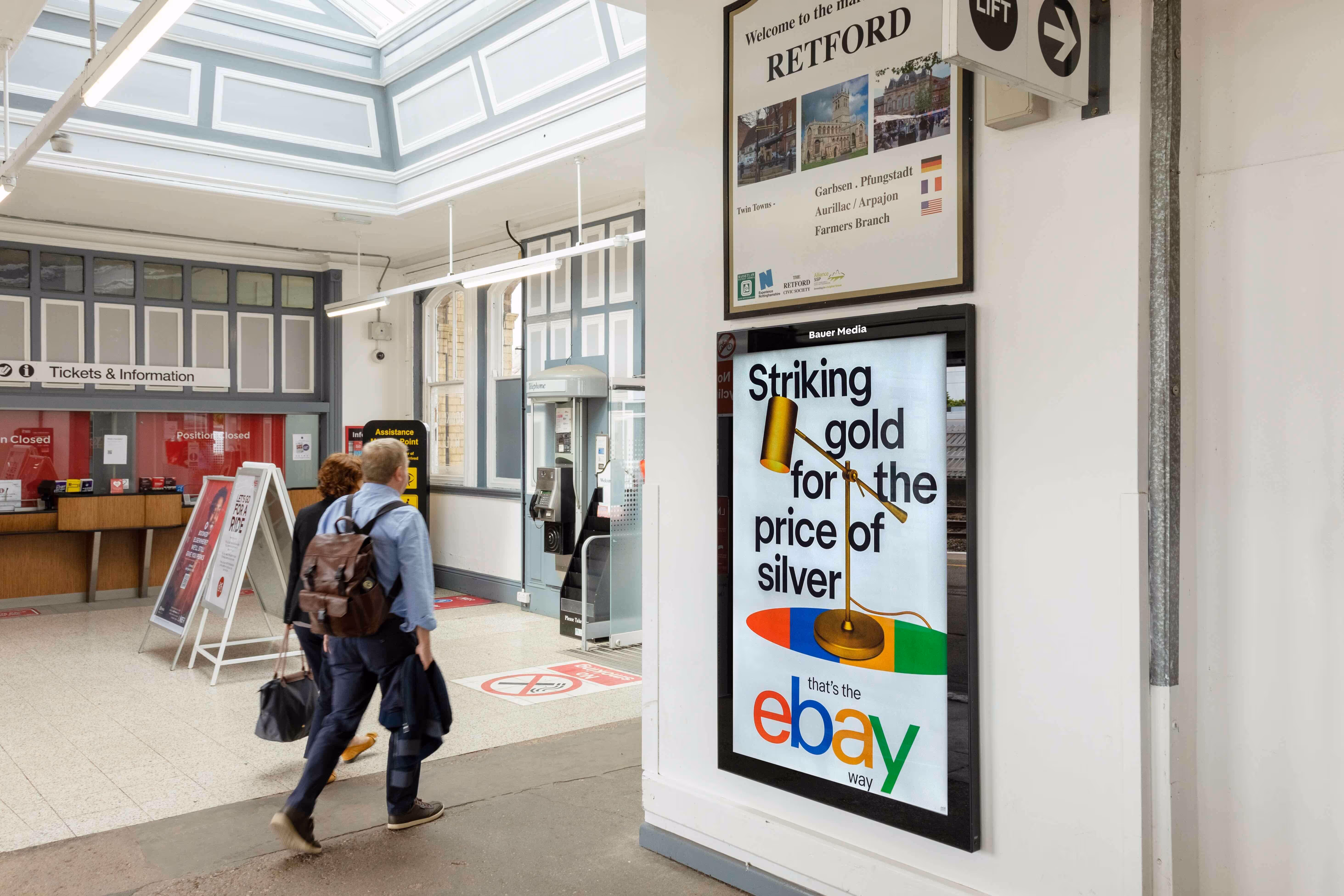 Rail station concourse with billboard showing Ebay ad
