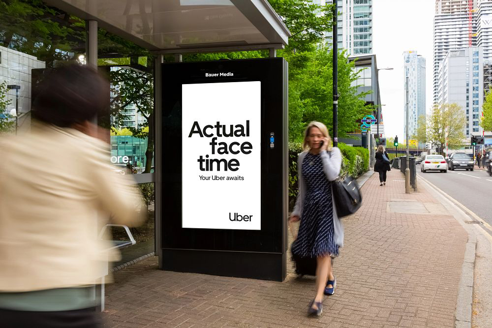 Uber Summer campaign on an Adshel Live panel with people walking by