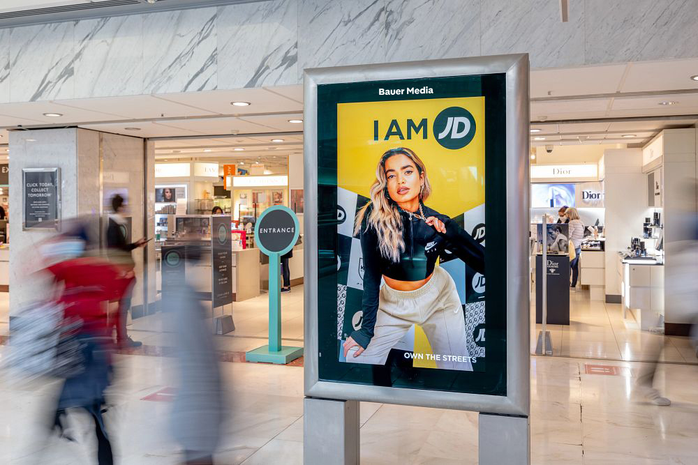Shopping mall digital screen with a JD ad campaign, with Dior in the background.