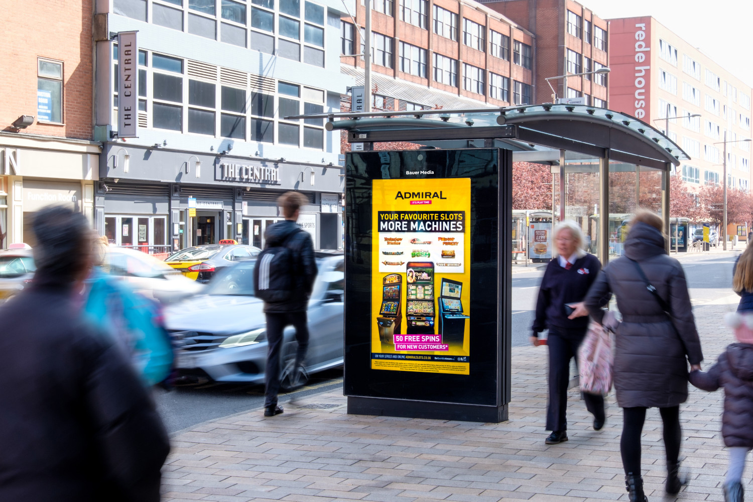 Admiral casino advertising on a bus shelter with people walking past