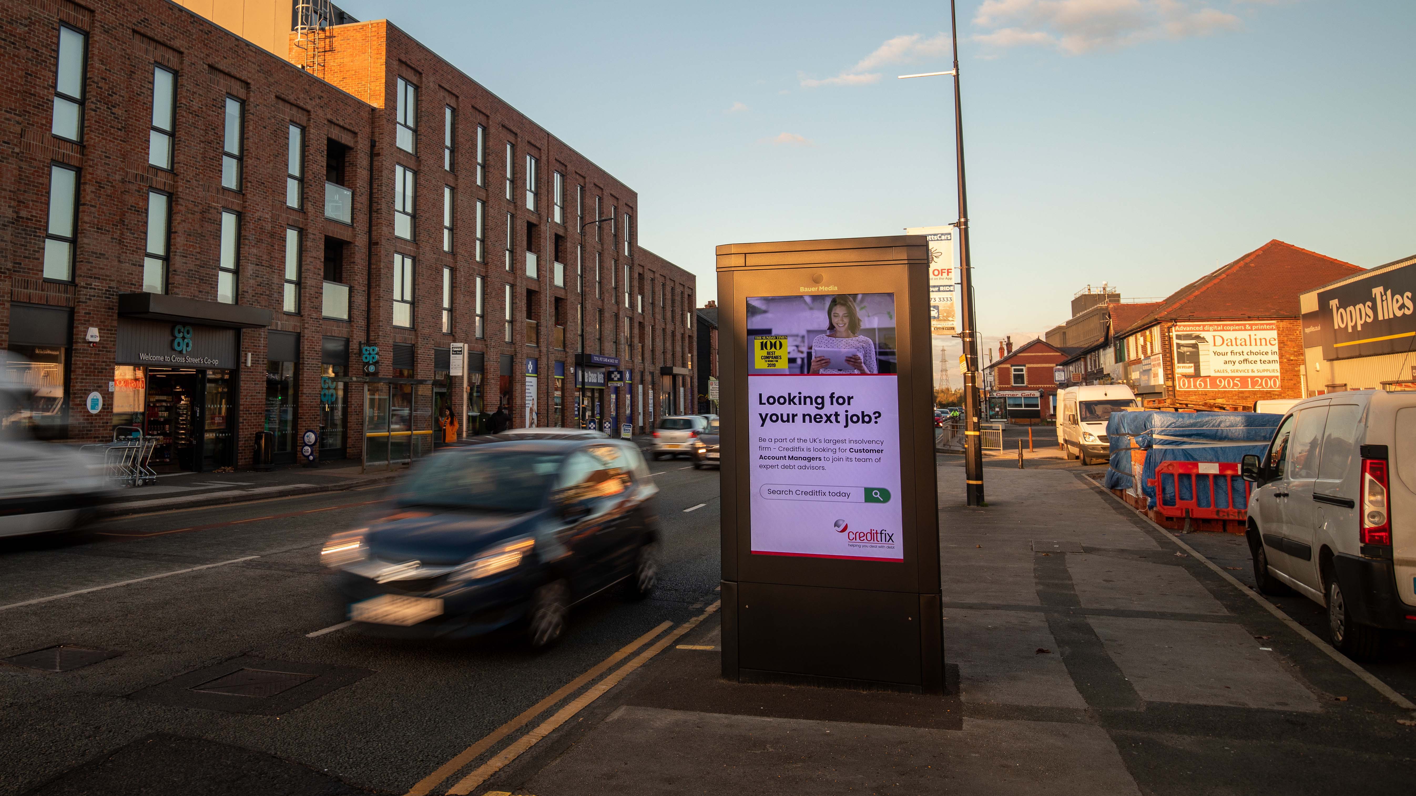 Creditfix advertising on a digital roadside screen with COOP in the background