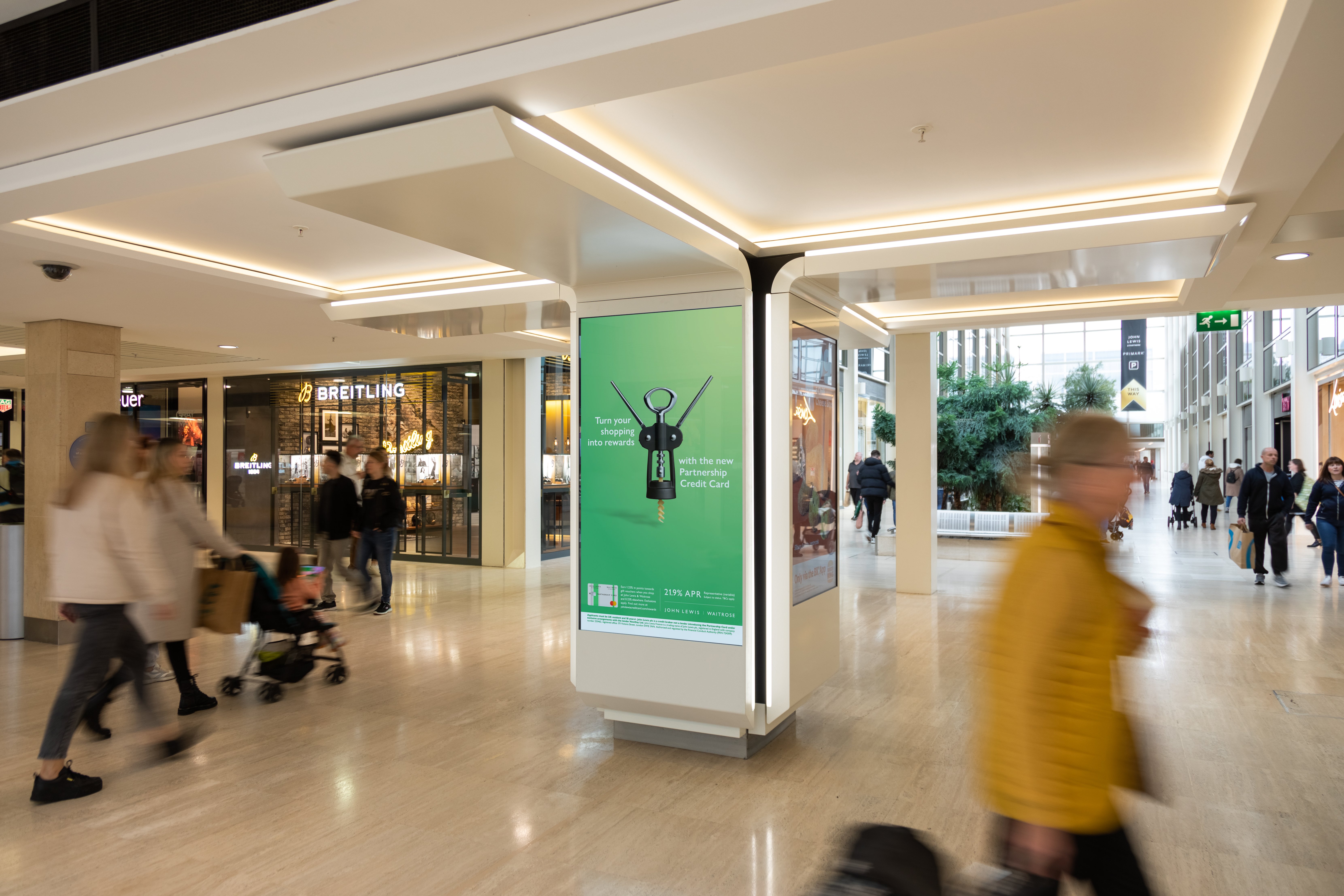 Bauer Media Outdoor's digital advertising screen in Centre MK shopping mall showing a John Lewis ad with people walking past