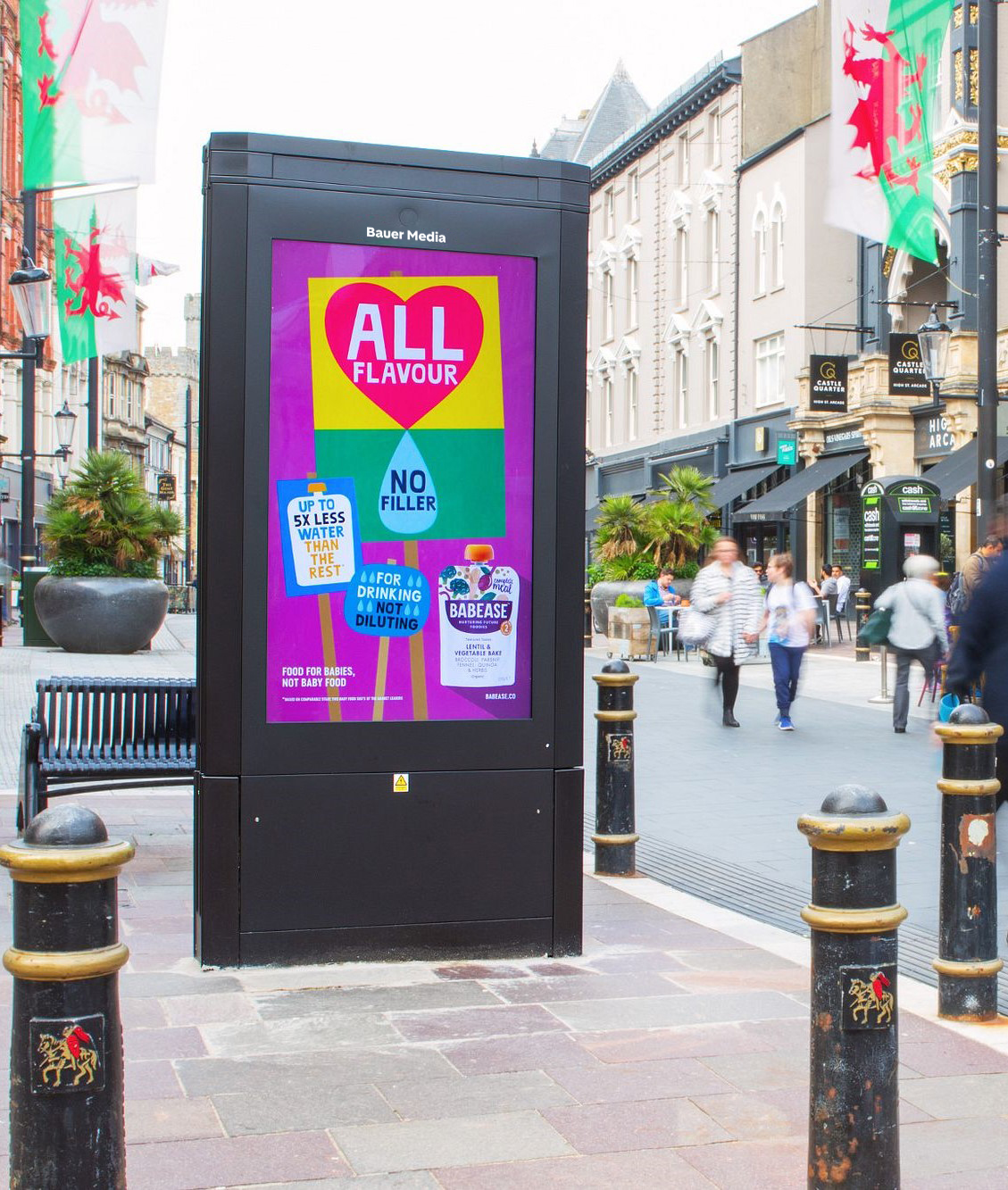 A digital advertising panel along a Welsh highstreet.