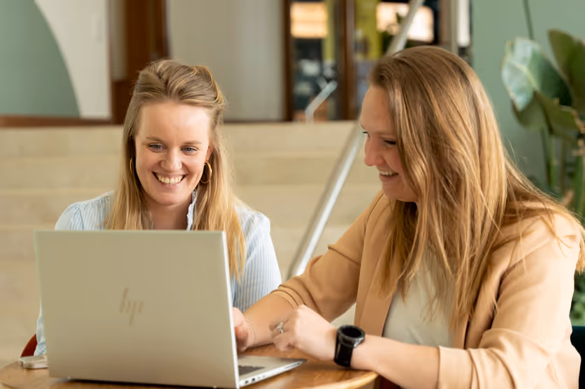 twee medewerkers kijken naar laptop.