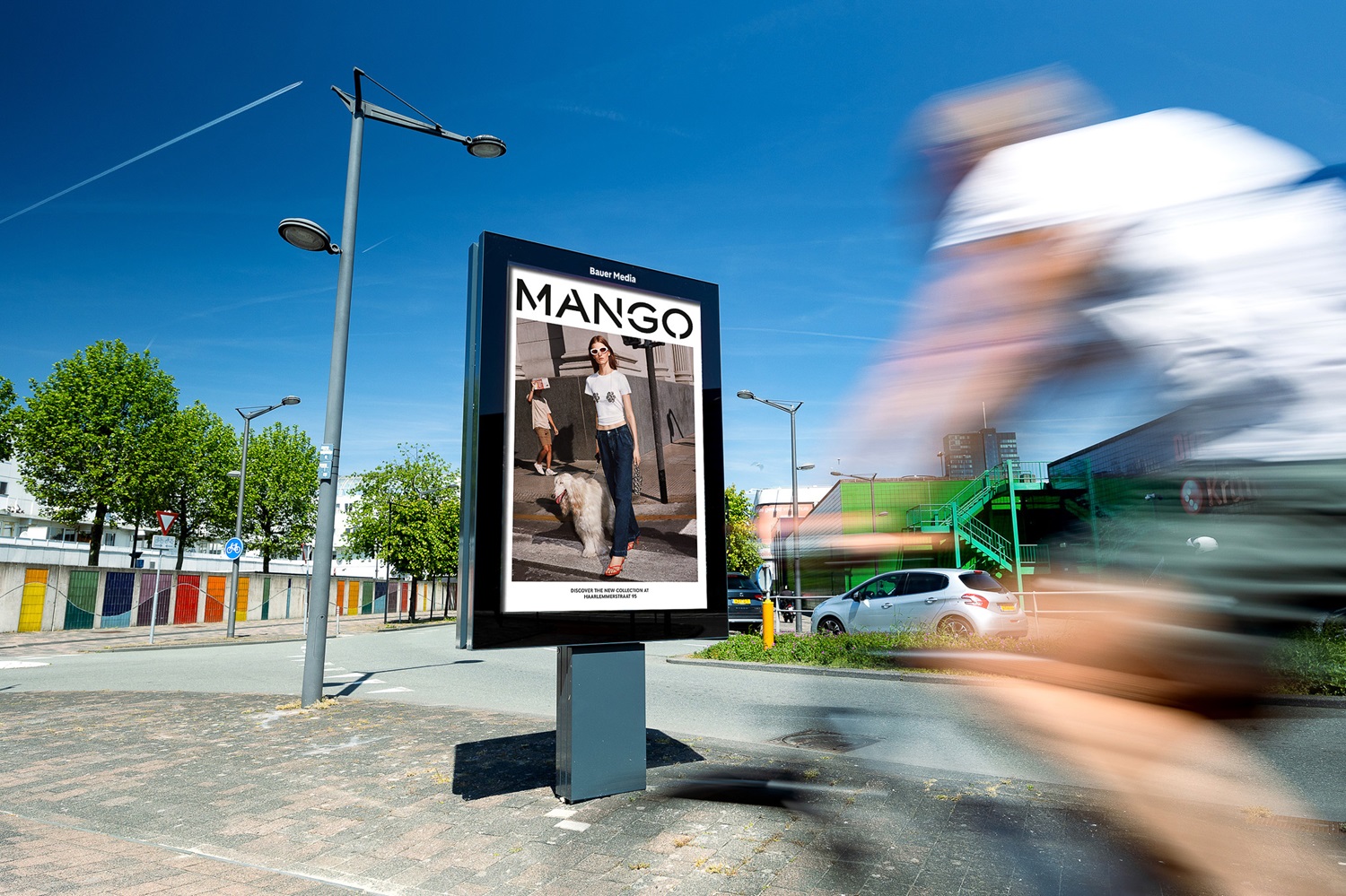 Man fietst langs vrijstaand reclamepaneel in Almere Centrum.