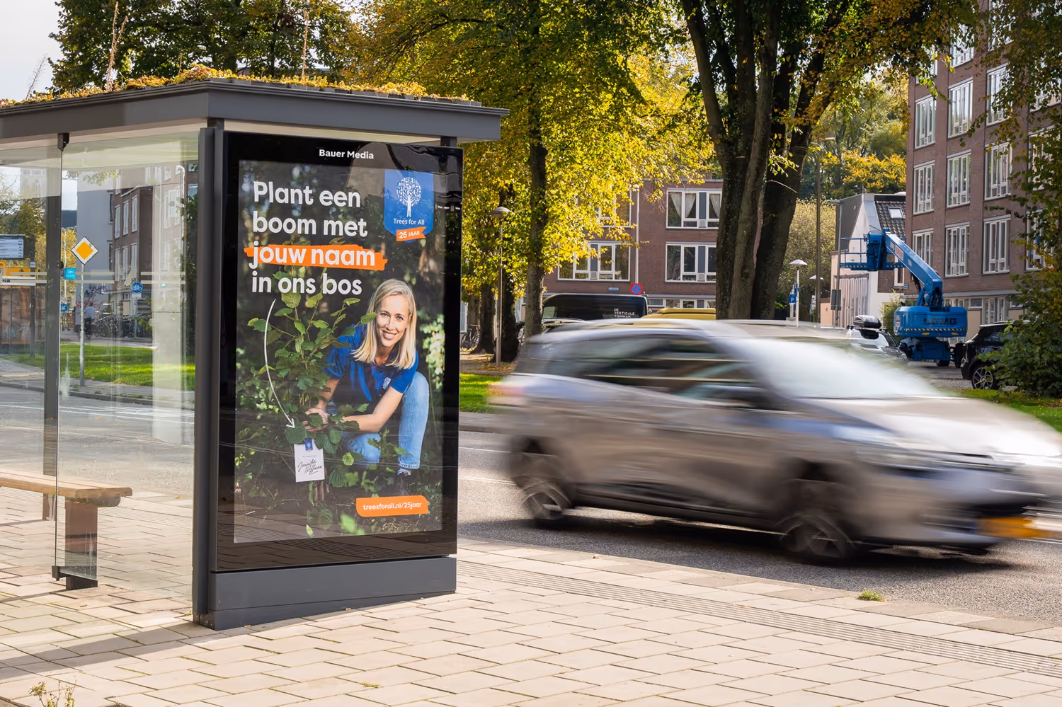 Bushalte met groen sedum dak en voorbijgaande auto.
