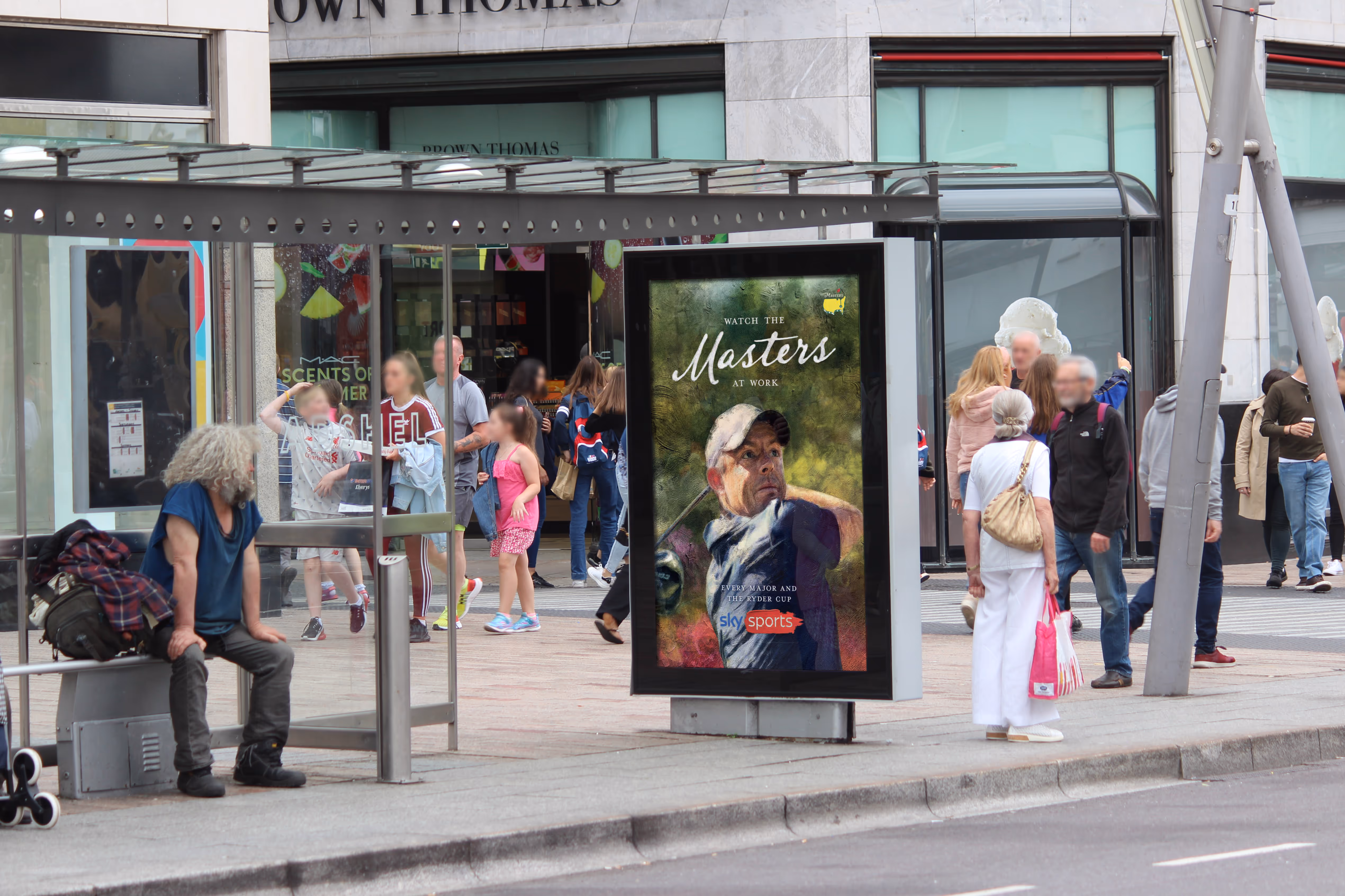 An Adshel 6-Sheet bus shelter displaying an advertisement for Sky Sports Golf, on a busy shopping street in Cork City