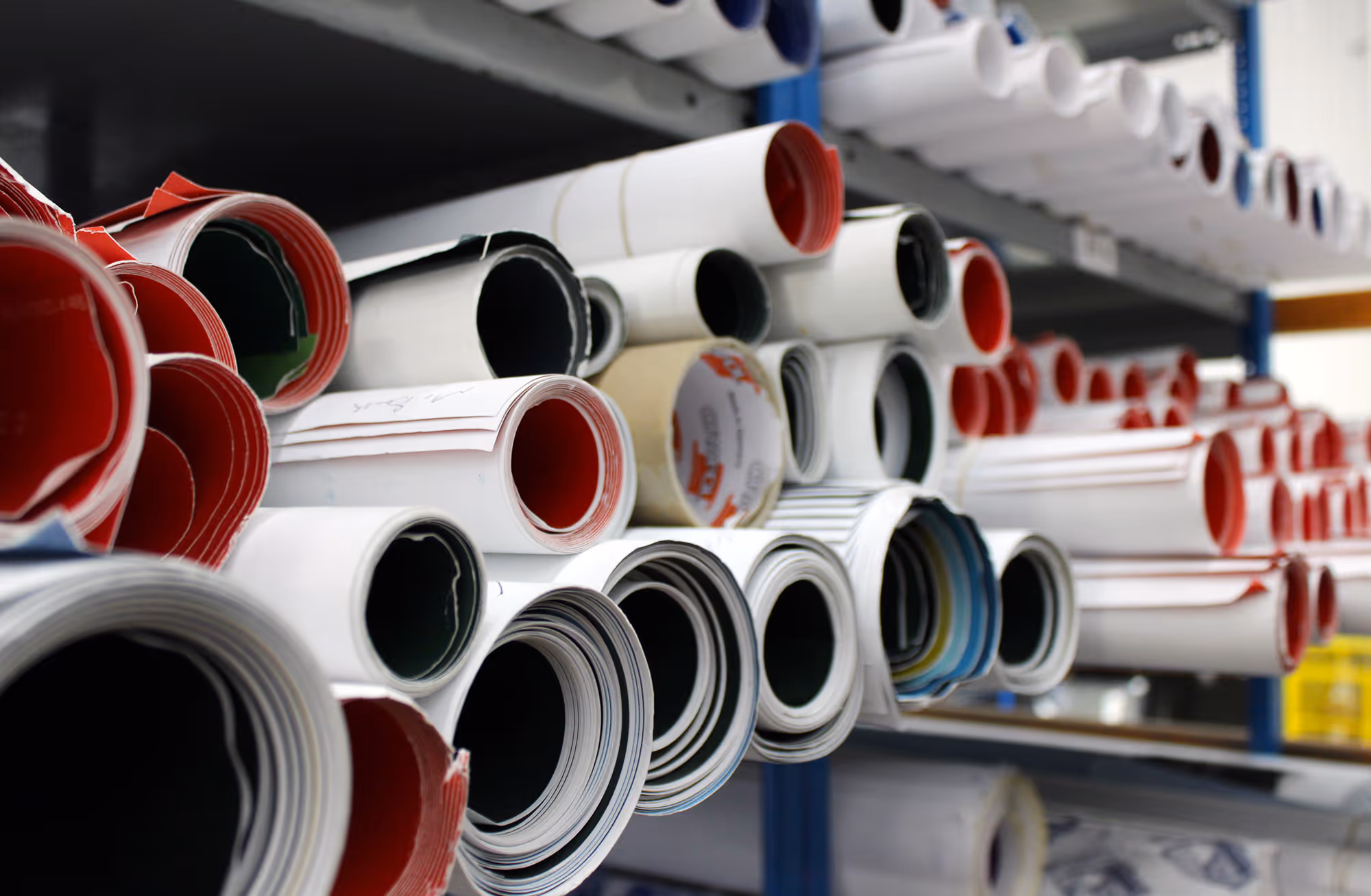 rolled up advertising posters on a warehouse shelf