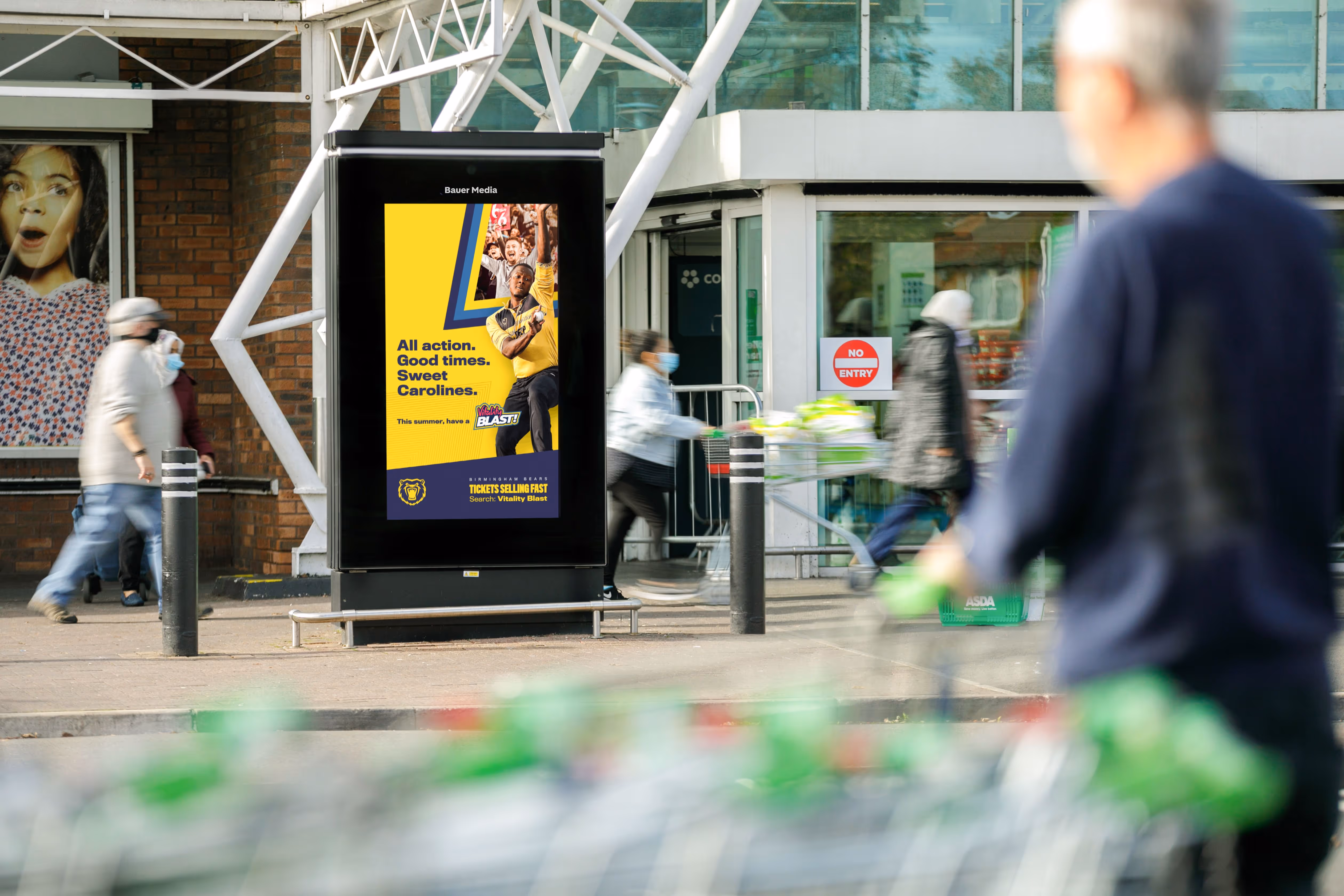  Birmingham Bears Vitality Blast campaign advert on a digital screen outside an ASDA as shoppers go in and out of the store during the day