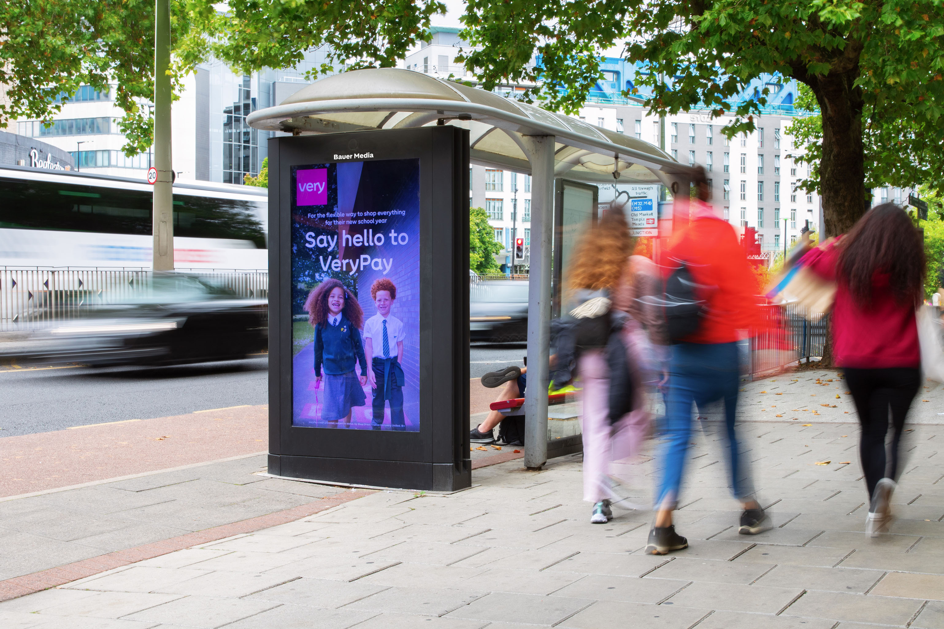 A bus shelter with a screen displaying an advert for Very.com