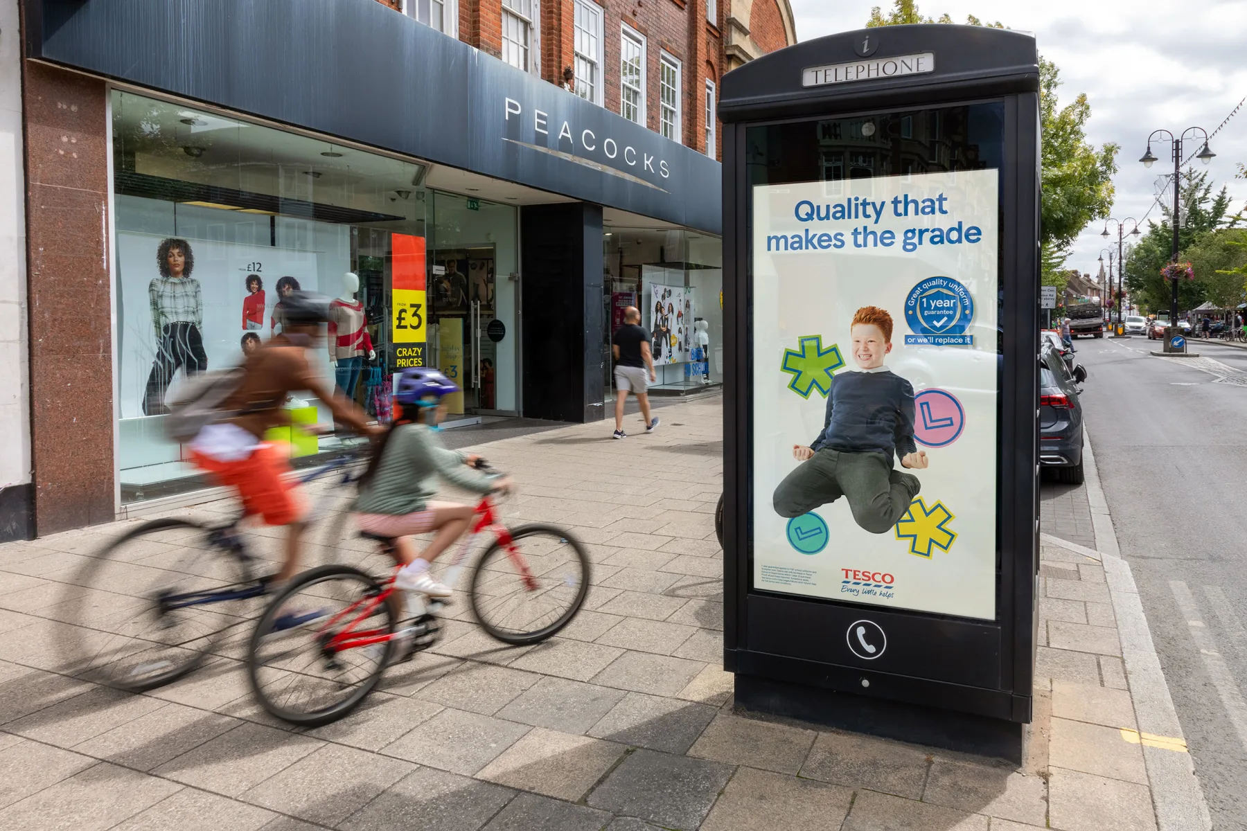 A digital screen on a high street showing an ad for Tesco