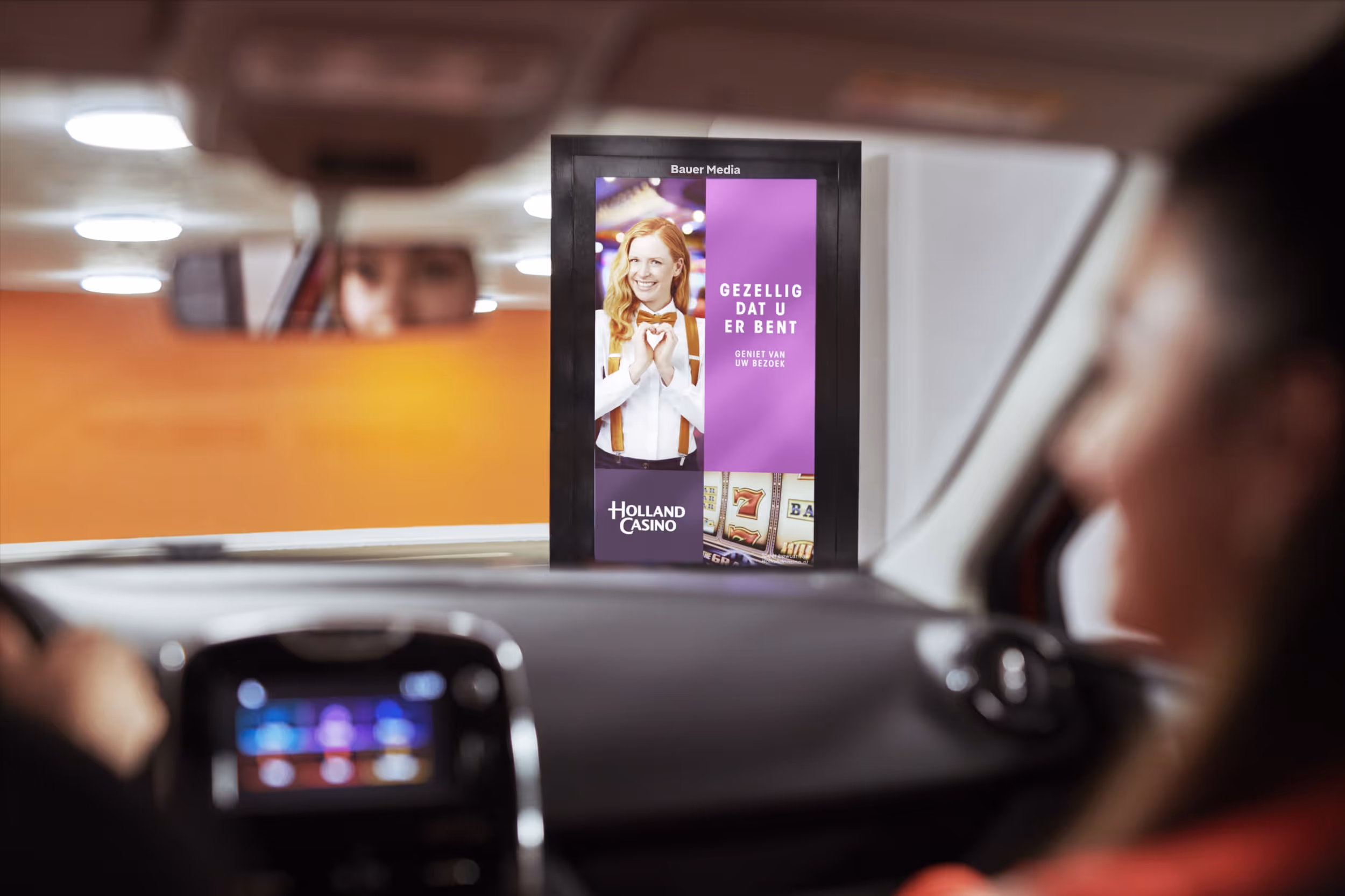Vanuit de auto zien we een digitaal reclame scherm