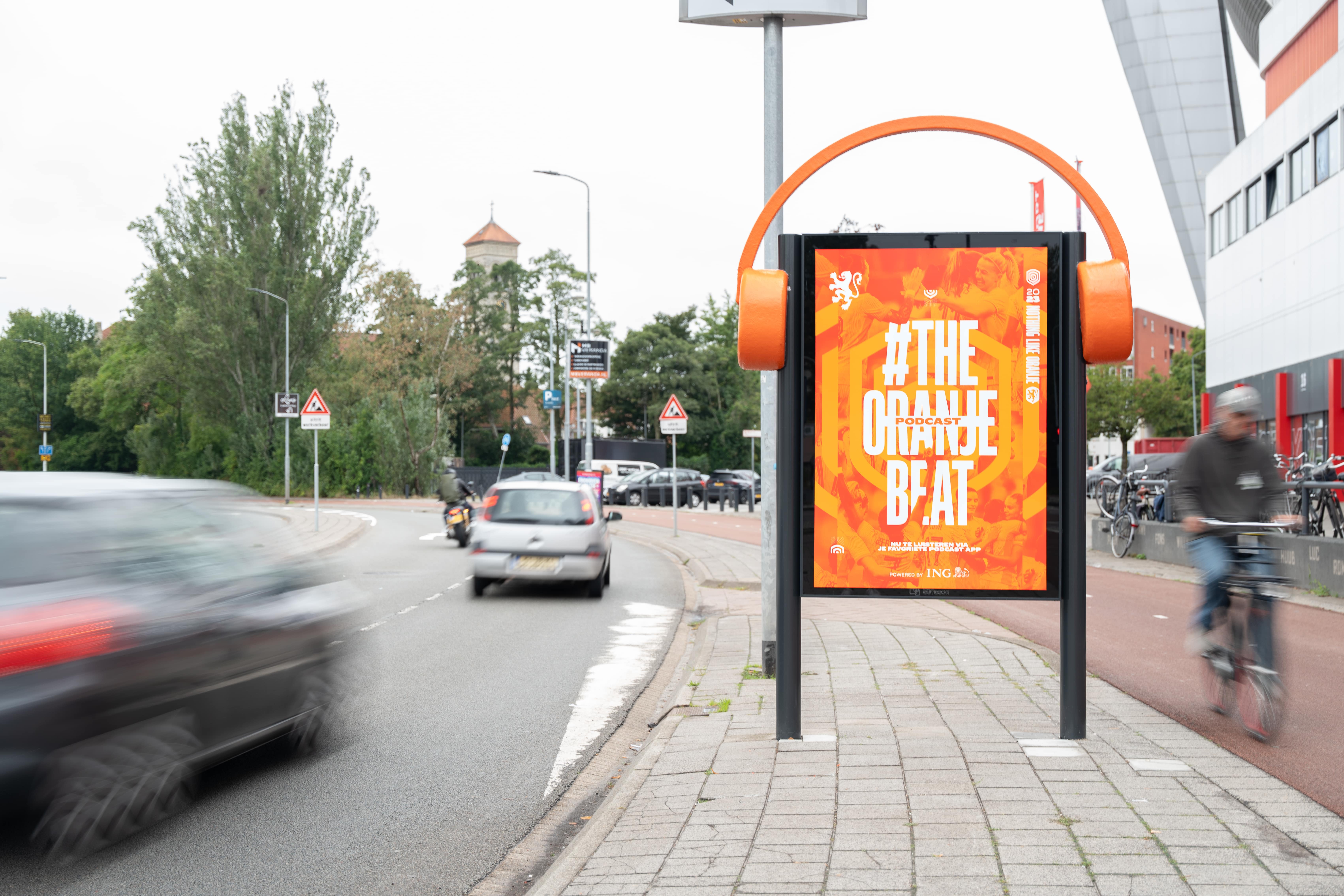 Reclameobject langs weg met Oranje reclame en grote koptelefoon op object