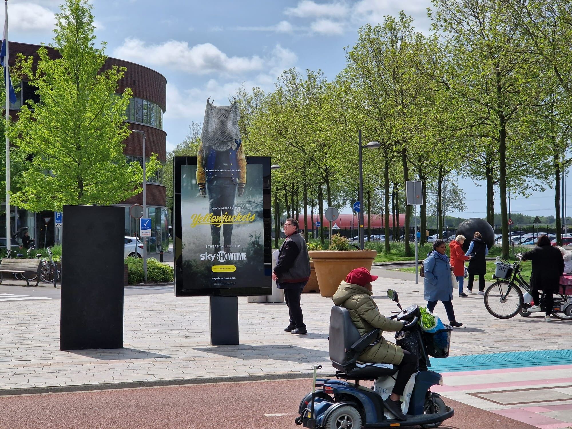 Reclameobject met Yellow Jackets reclame en voetgangers die voorbij lopen
