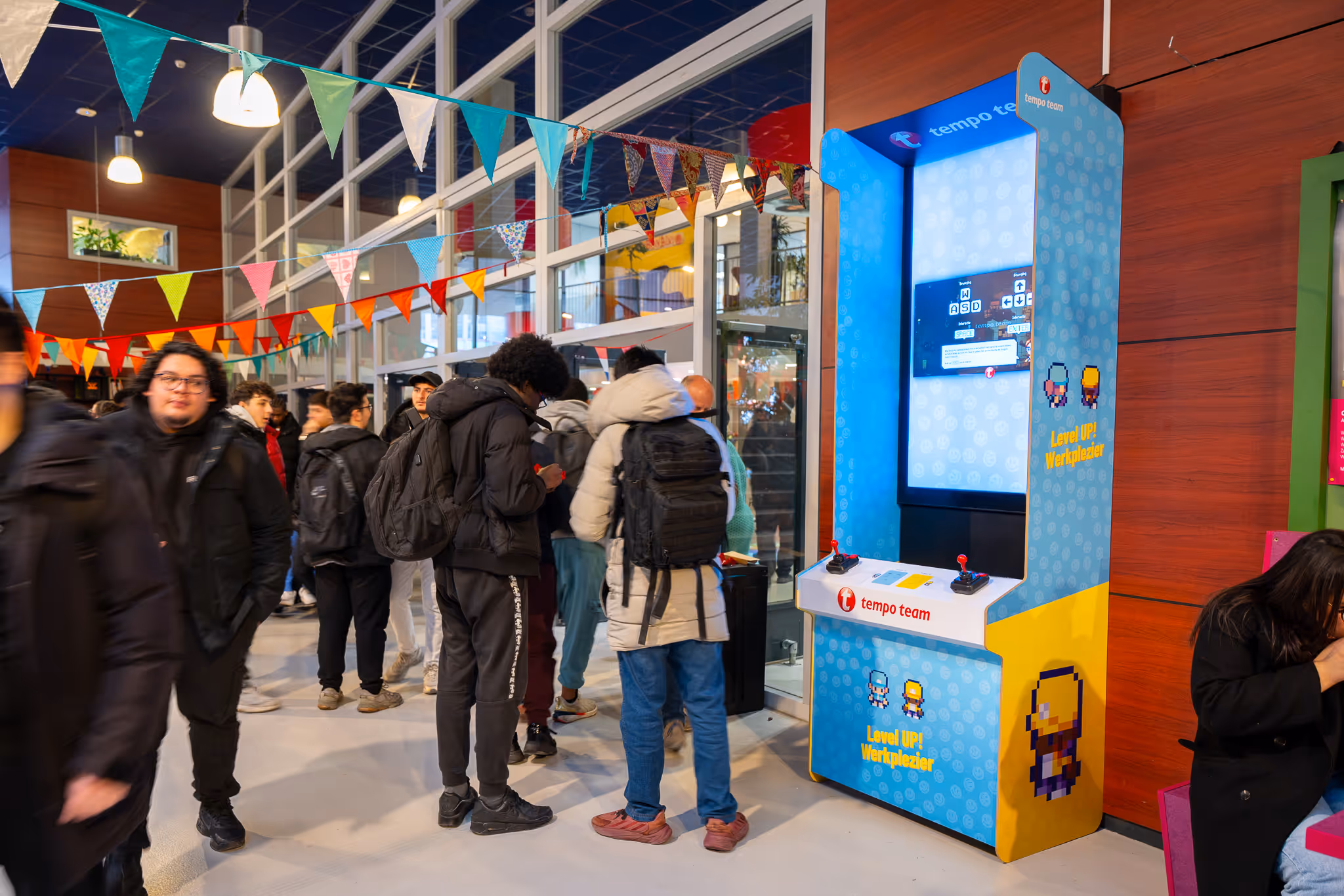 Digitaal scherm als game console met Tempo Team game in schoolkantine met scholieren