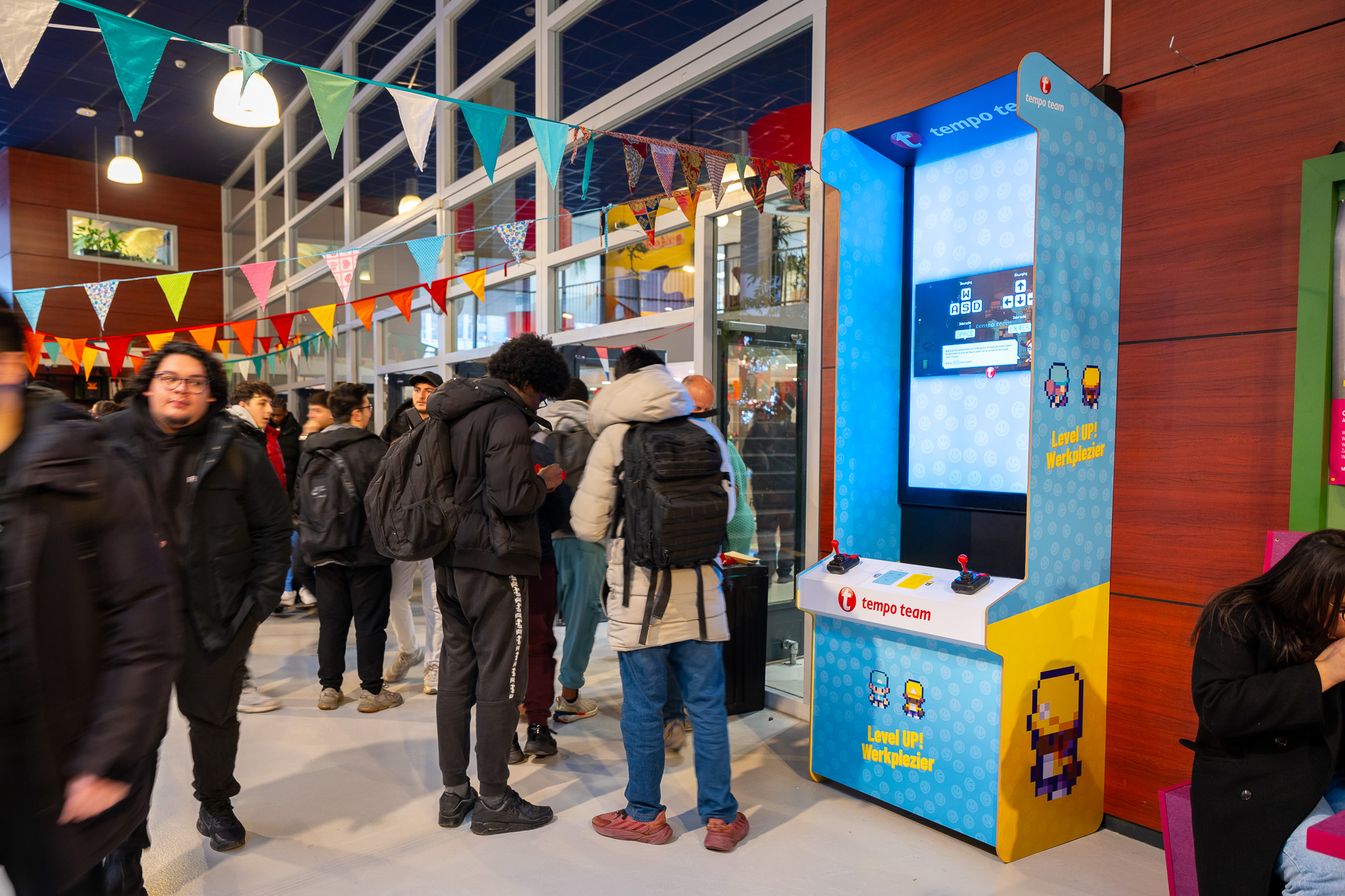 Digitaal scherm als game console met Tempo Team game in schoolkantine met scholieren