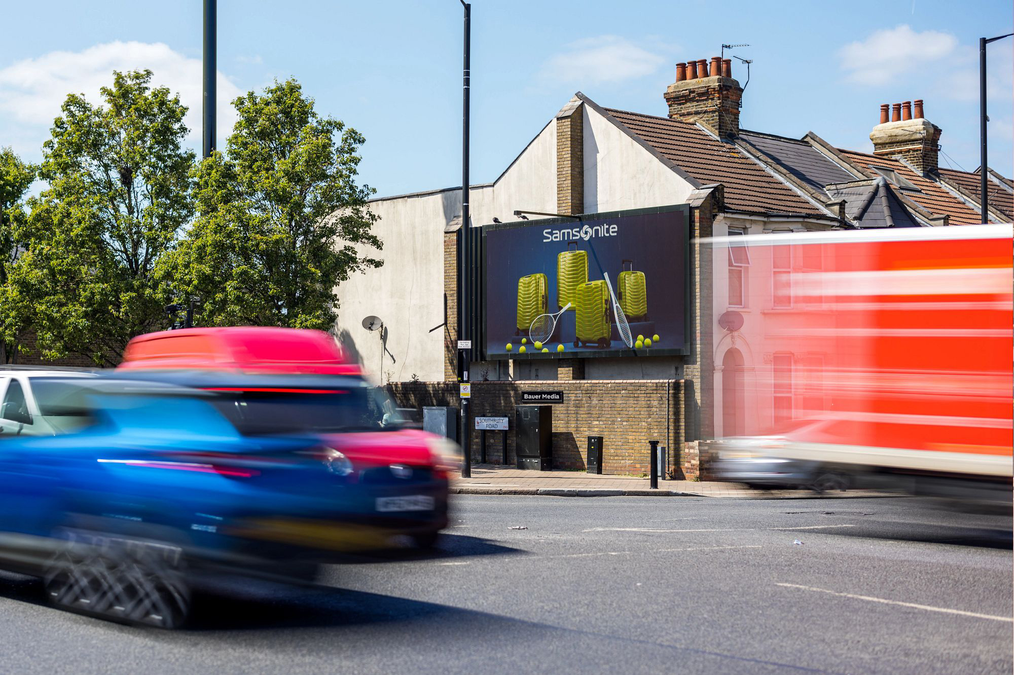 A billboard campaign with traffic driving by
