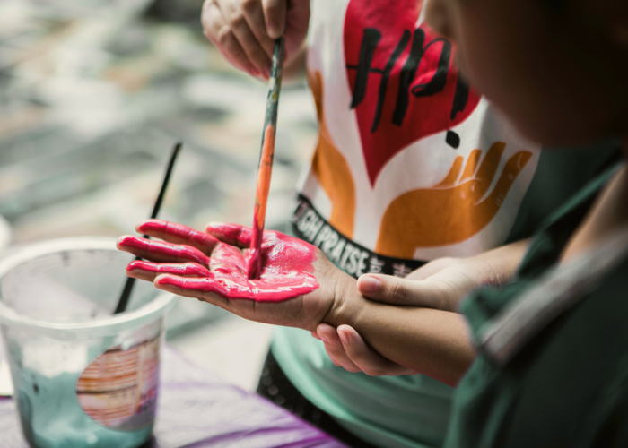 A child who paints on his hand with paint