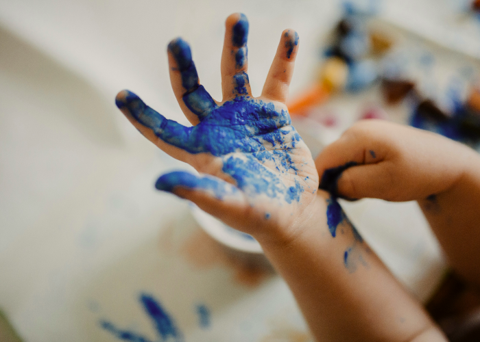 A child who paints on his hand with paint