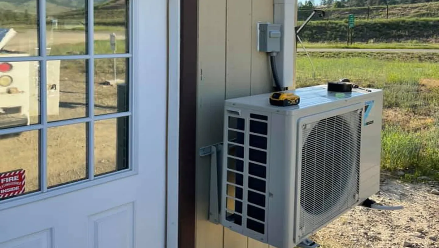 Air conditioning unit outside building with yellow tool on top