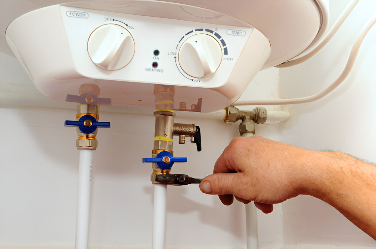 Hand adjusting valves on a white electric water heater