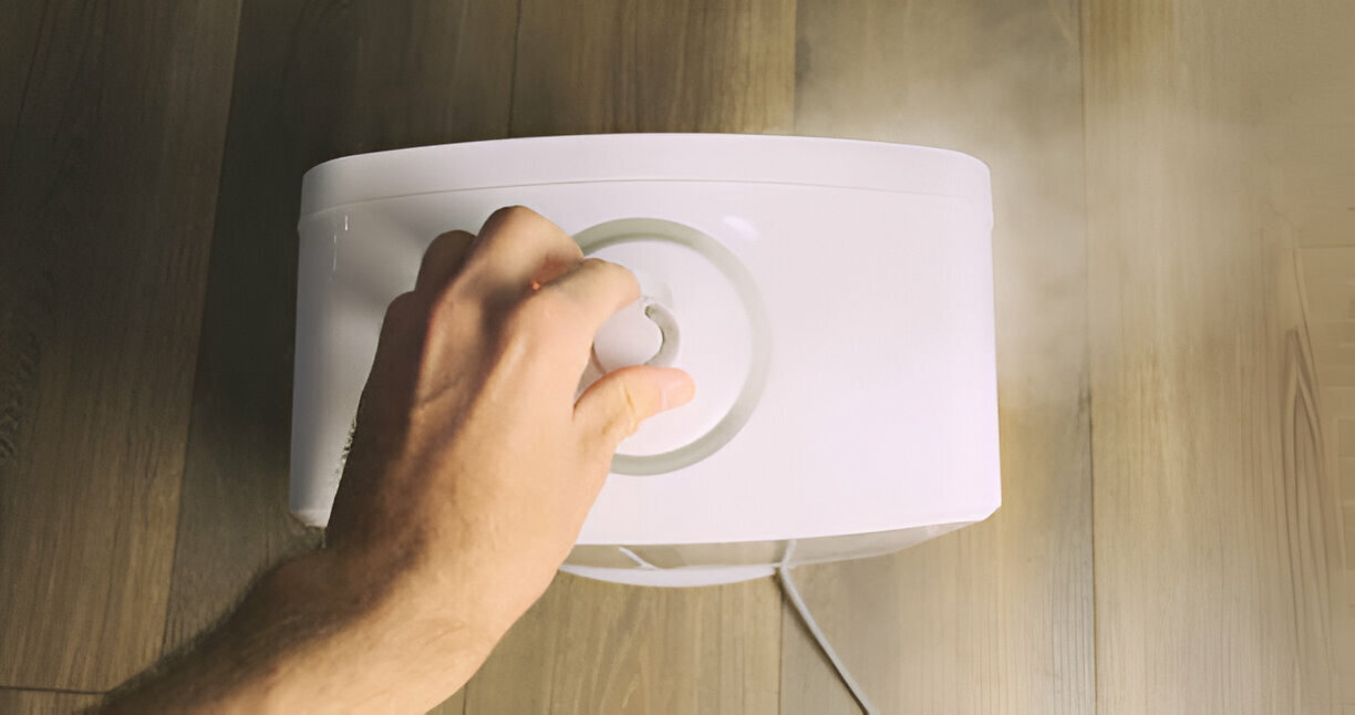 Hand adjusting an air purifier control knob