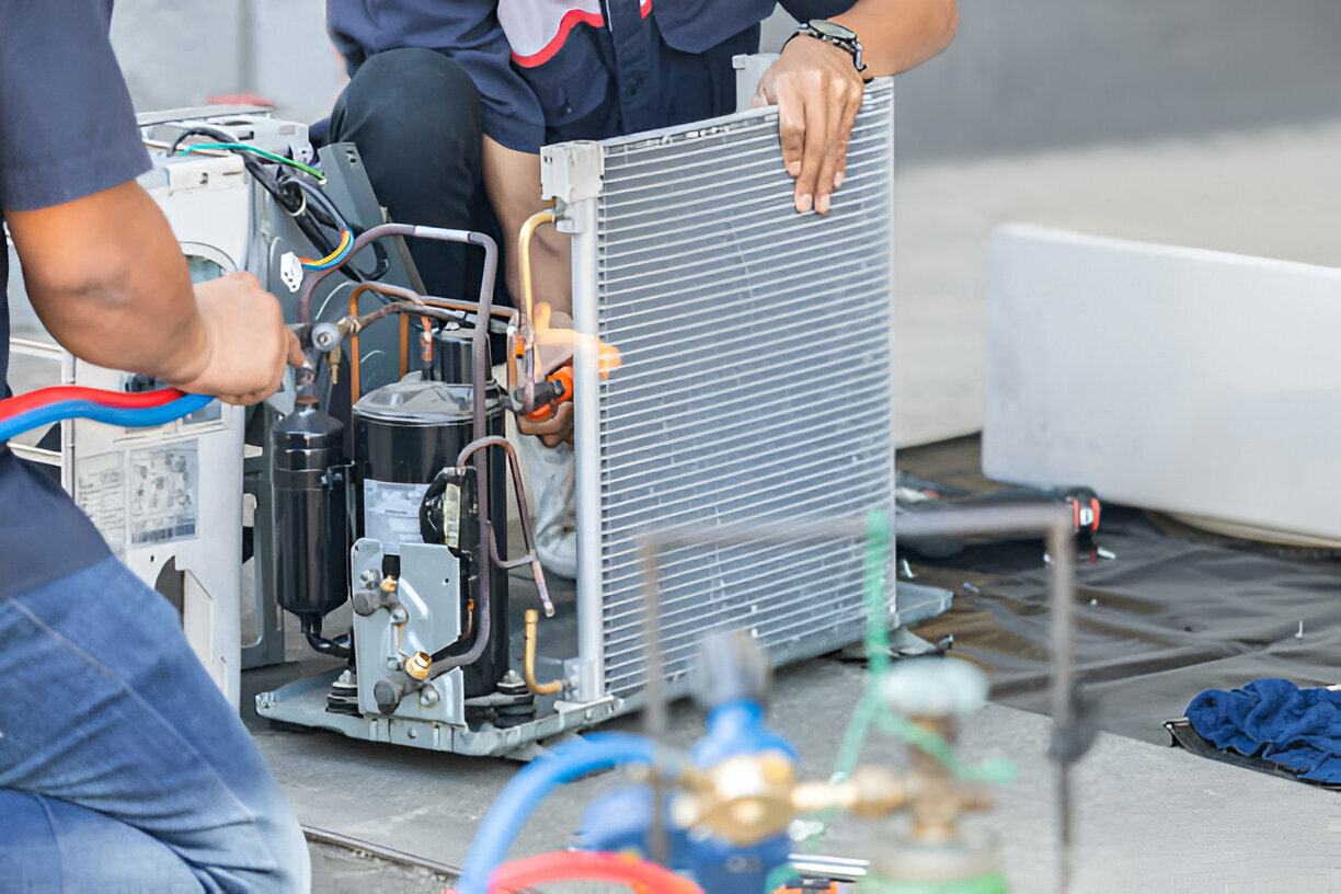 Technician repairing air conditioning unit with condenser and compressor