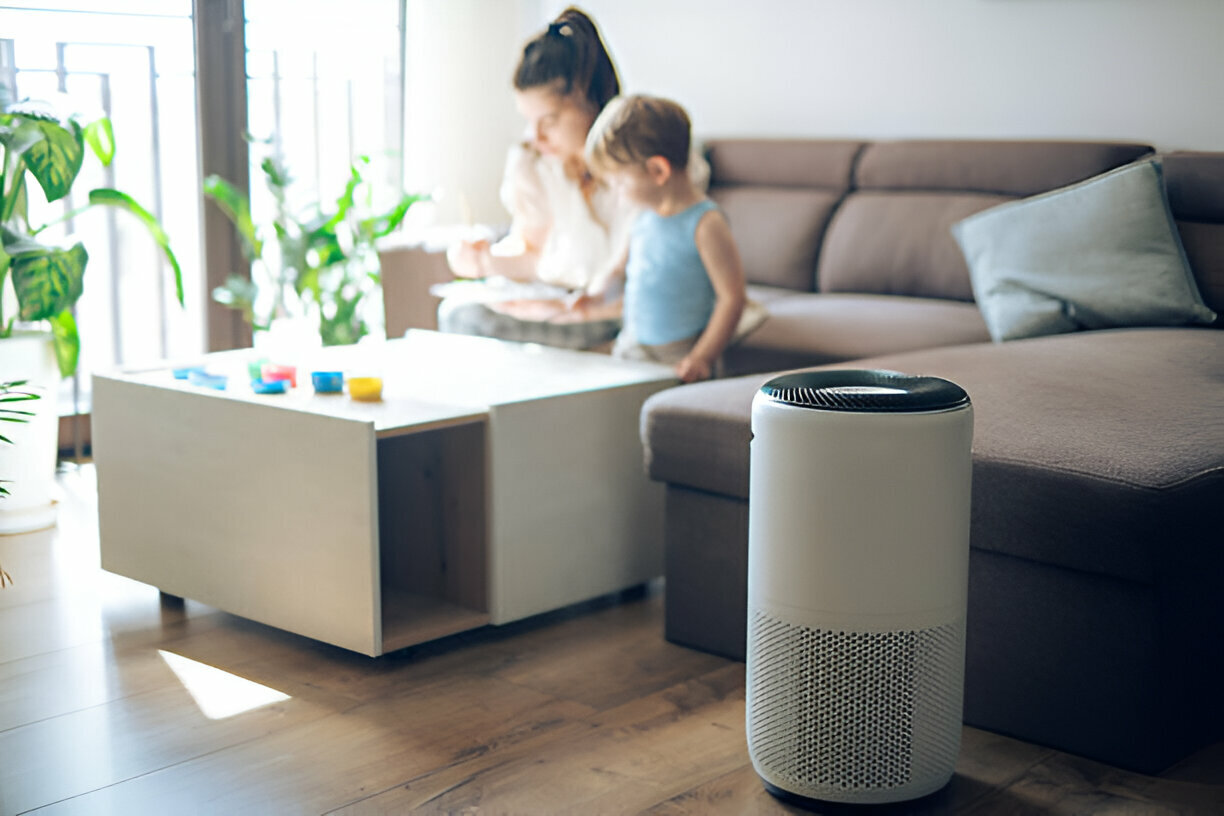 Air purifier in living room with caregiver and child playing nearby