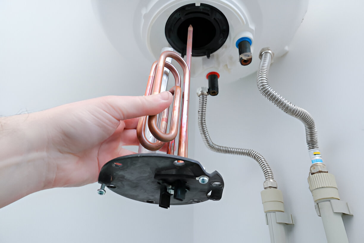 Hand removing copper heating element from water heater