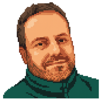 Porträtt på en leende Niklas med blont hår och i en grön tröja.