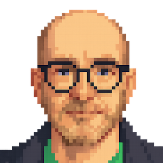 Porträtt på Andrew i svarta glasögon, mörk jacka och grön tröja.