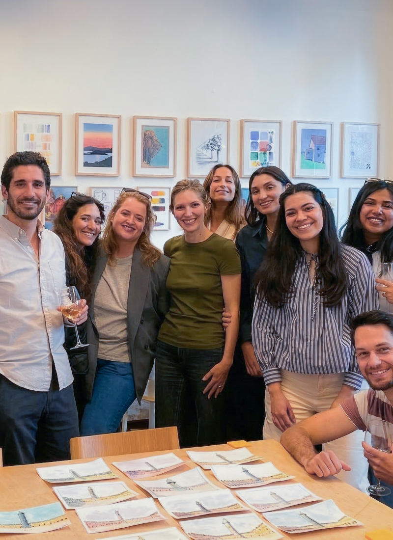 Main dessinant au crayon sur un carnet de croquis avec plusieurs crayons flous en arrière-plan.