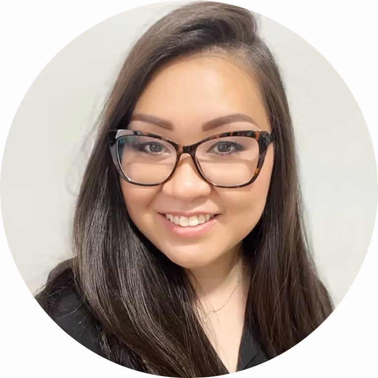 Smiling woman with glasses and dark hair, round professional headshot.