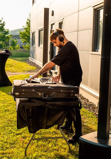 DJ en train de mixer de la musique au séminaire des Matrus en extérieur